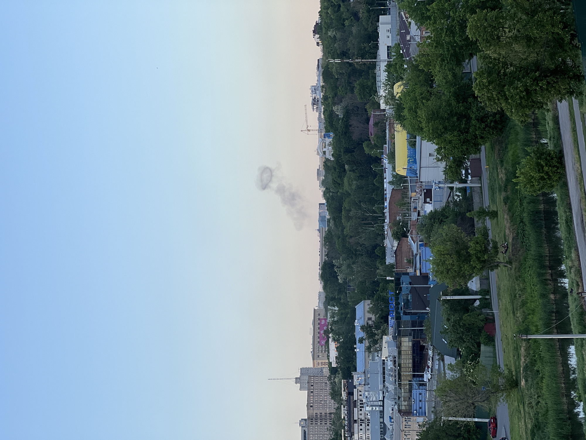 Ring-shaped smoke column observed over city skyline during evening