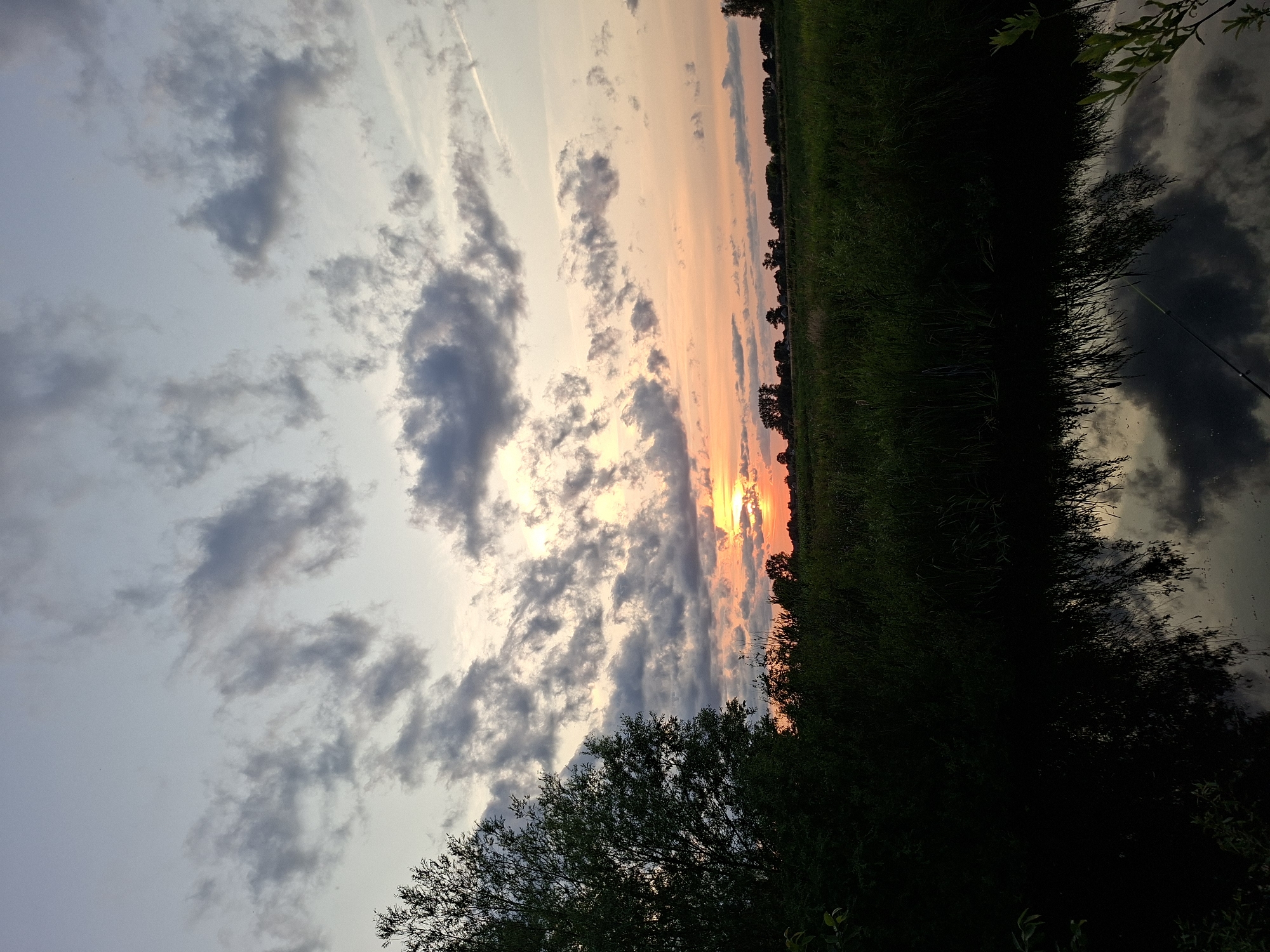 Quiet sunset over still water, sky shifting through dusk colors