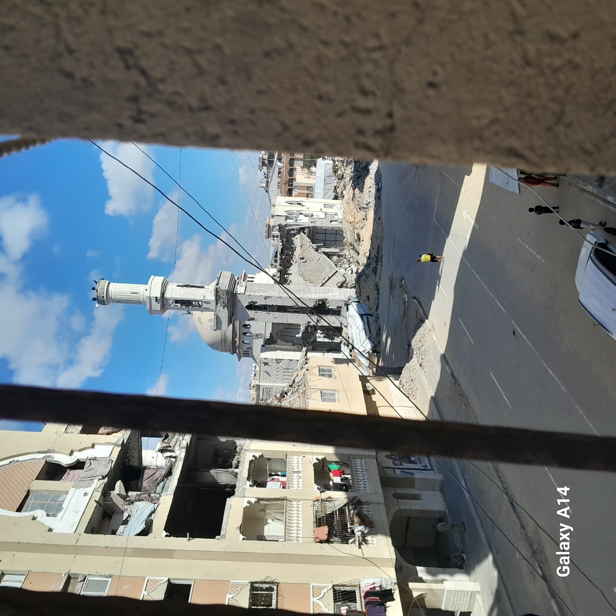 Damaged mosque with standing minaret documented in urban area