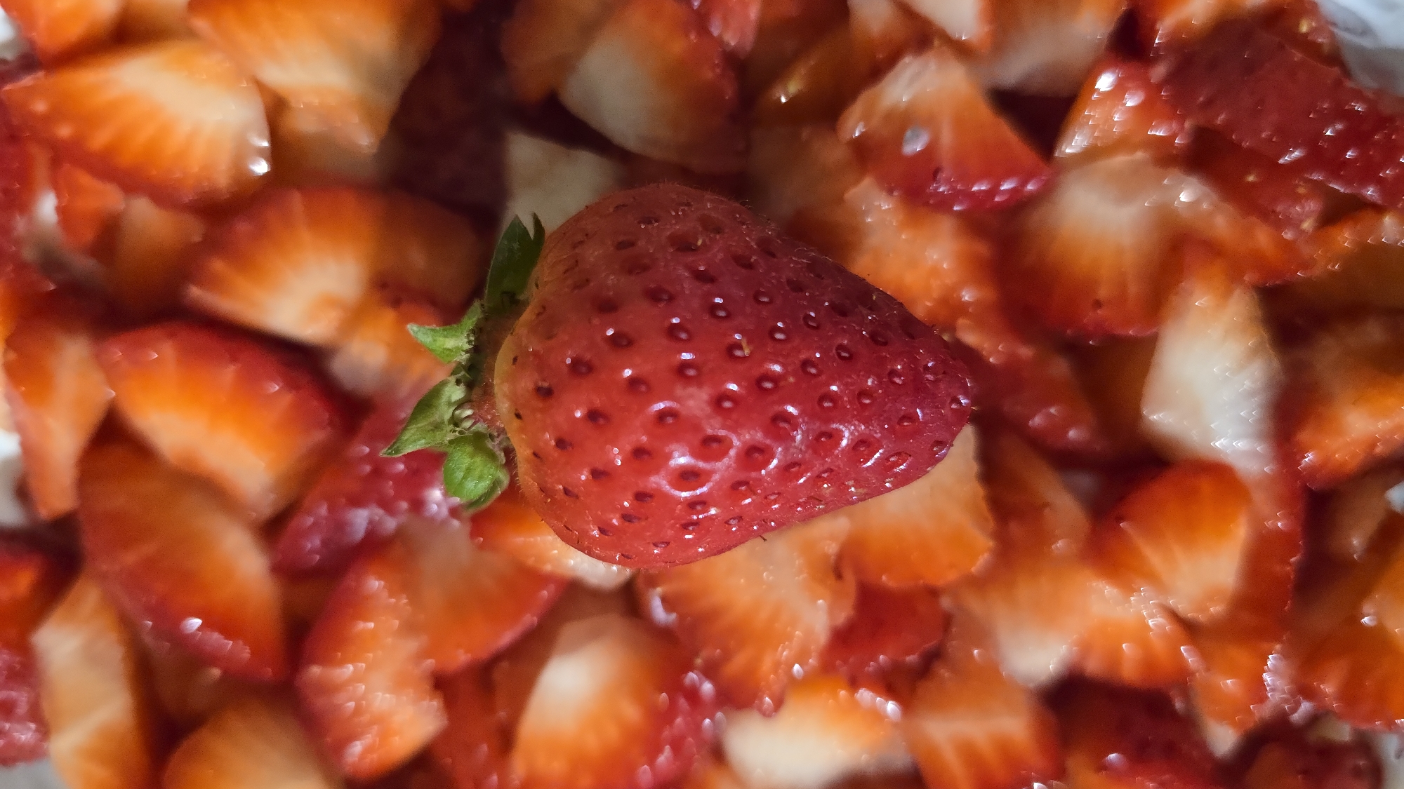 Person prepares fresh strawberries in food preparation scene