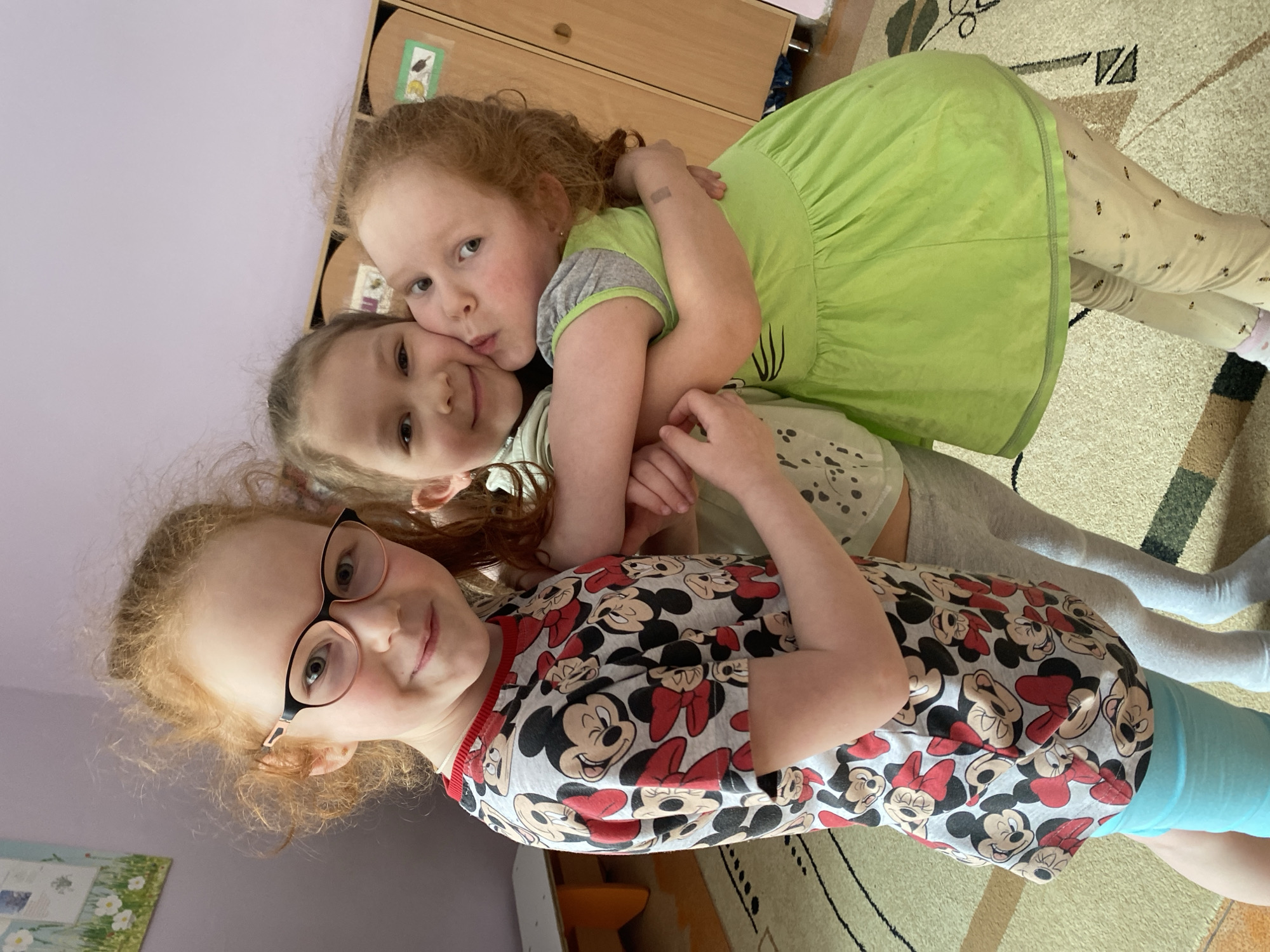 Three girls pose affectionately indoors in Izhevsk, Russia