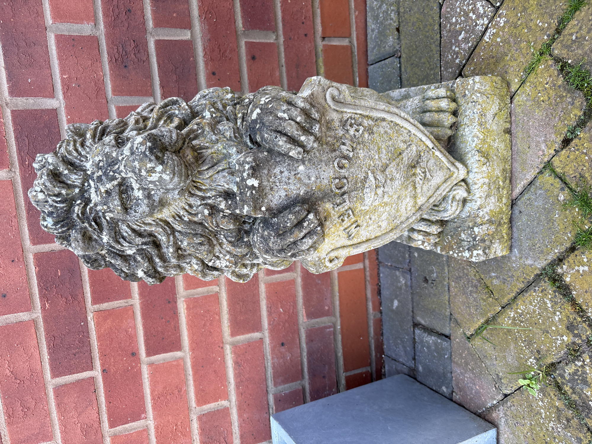 Stone lion statue with shield observed in Minsterley