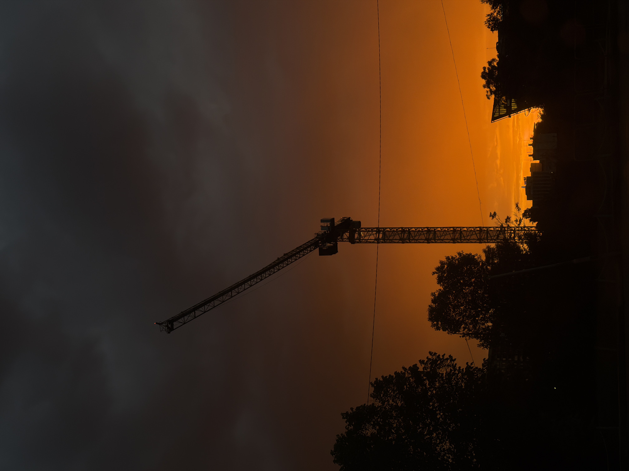 Dramatic sunset silhouettes construction crane over Sofia skyline