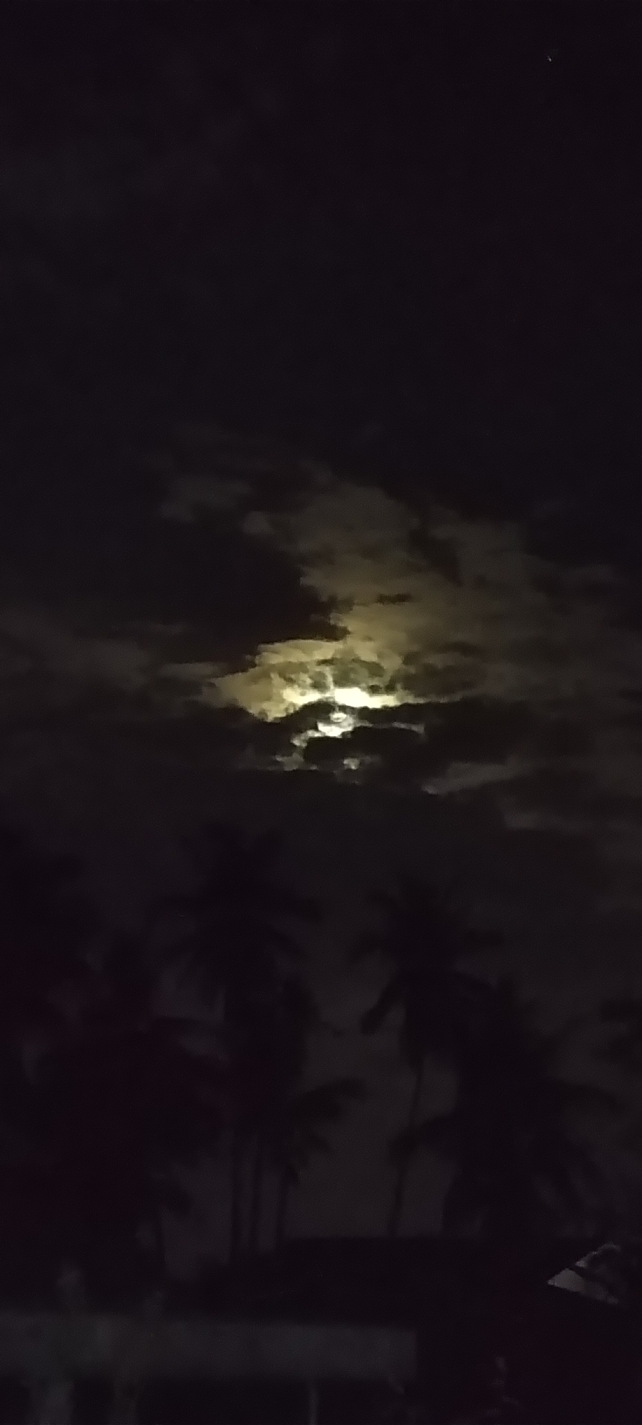 Bright yellow light observed illuminating overcast clouds at night
