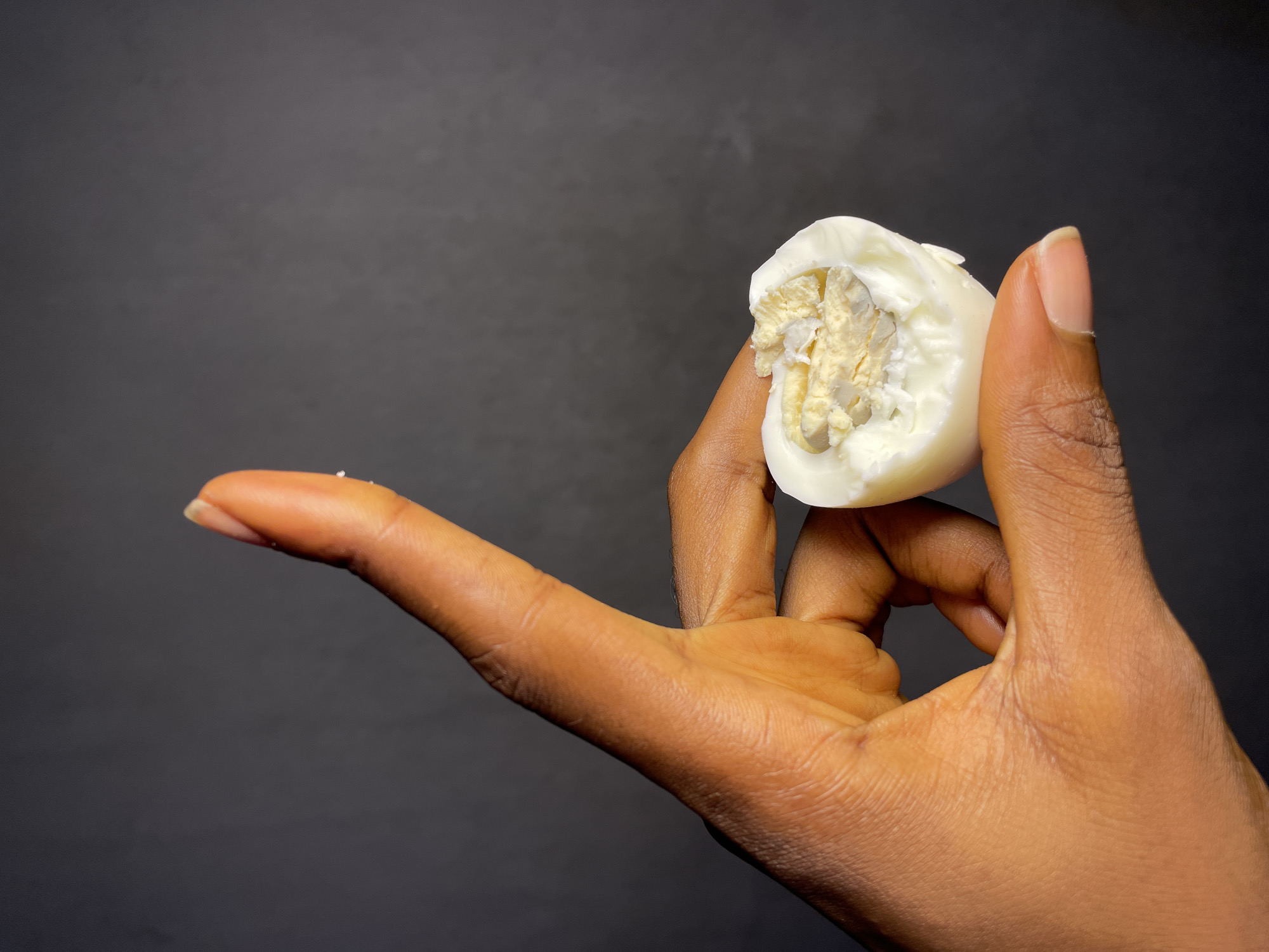 Person holds halved hard-boiled egg in Nkpor, Nigeria