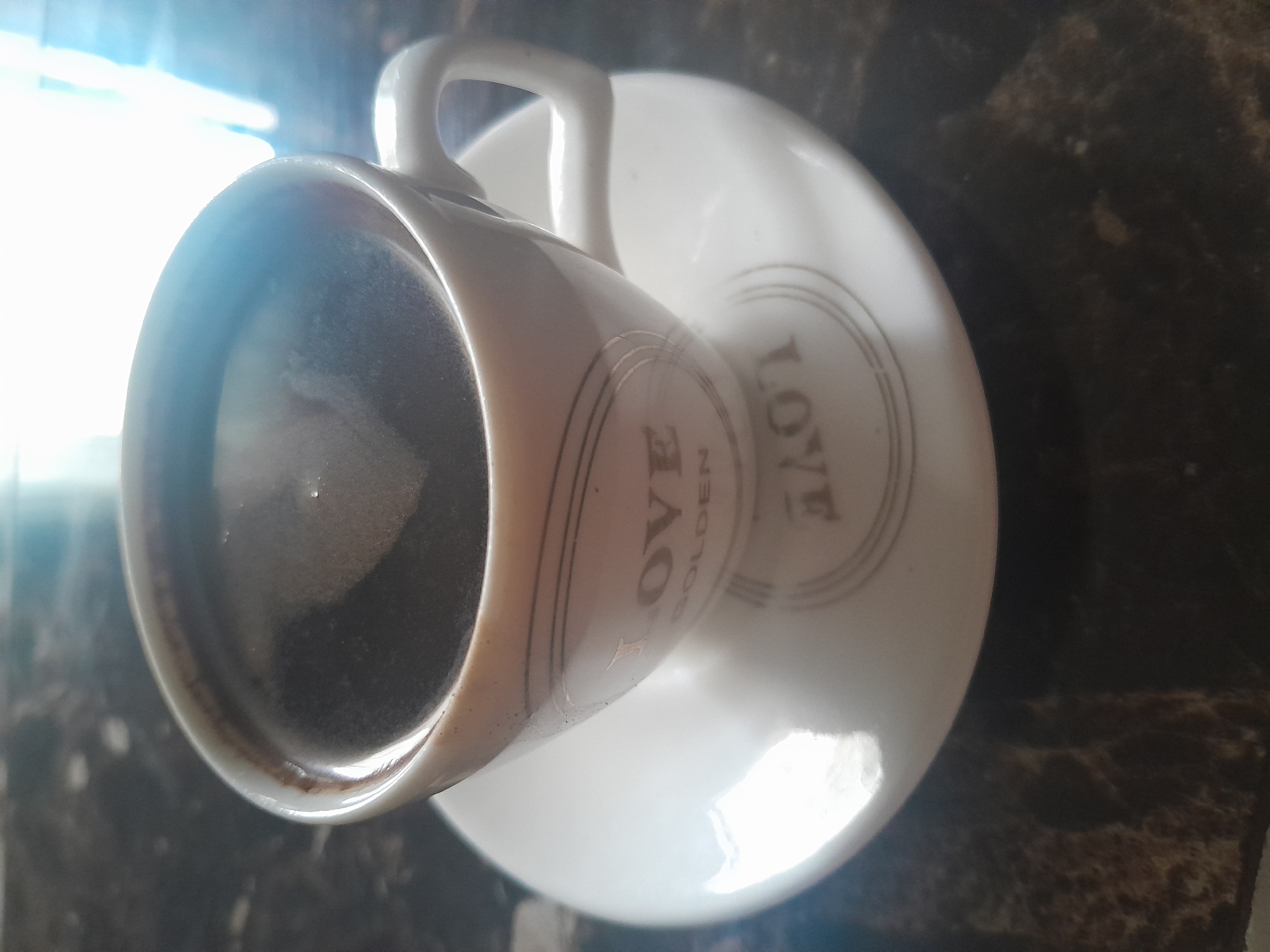 Patterned coffee cup observed on saucer early morning