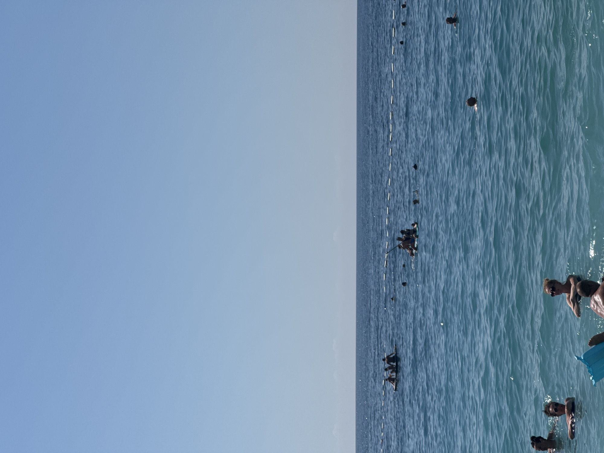 Crowded pebble beach day on Montenegro's Adriatic coast