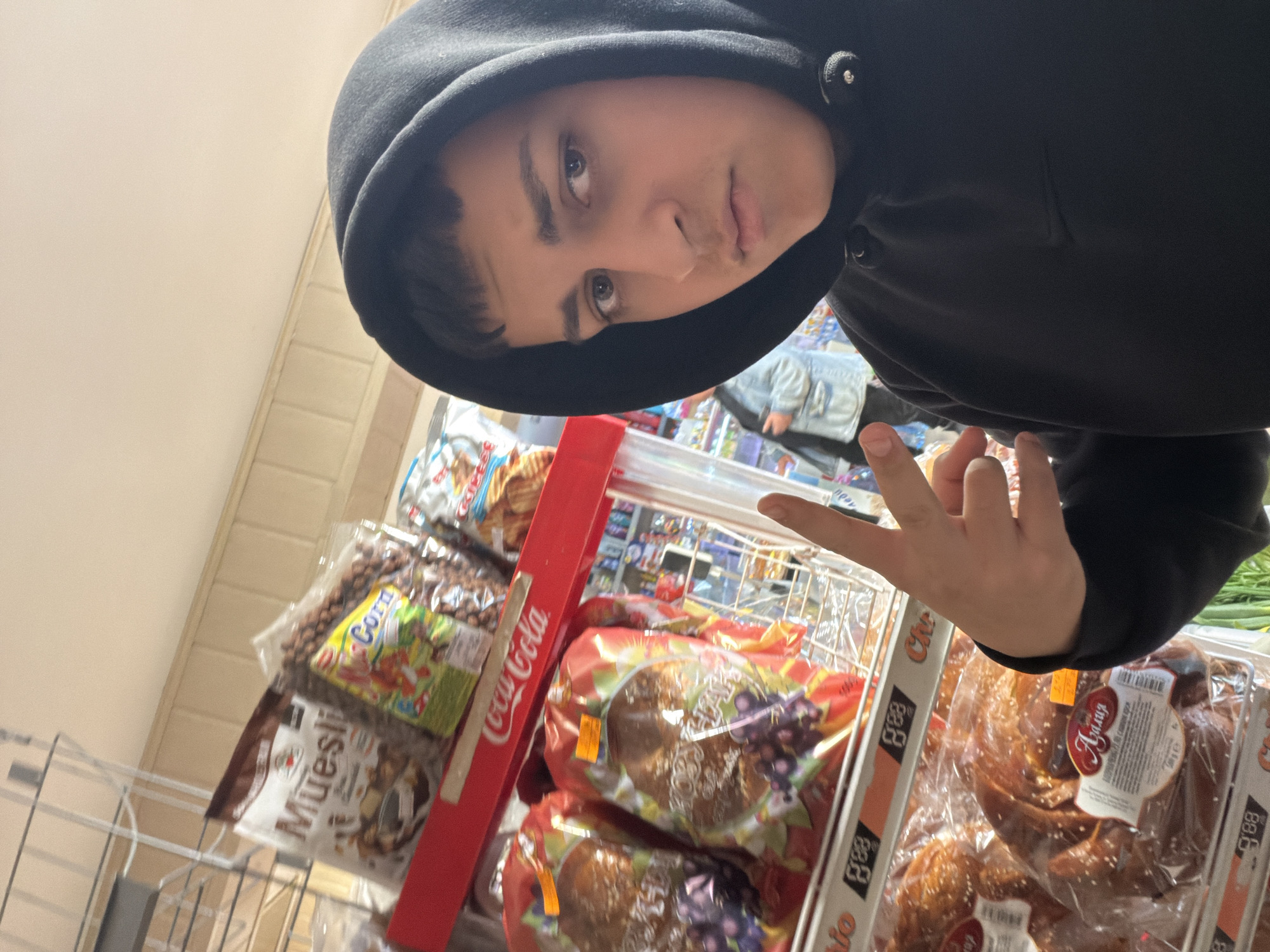Person takes selfies with rock gestures in Bulgarian grocery store