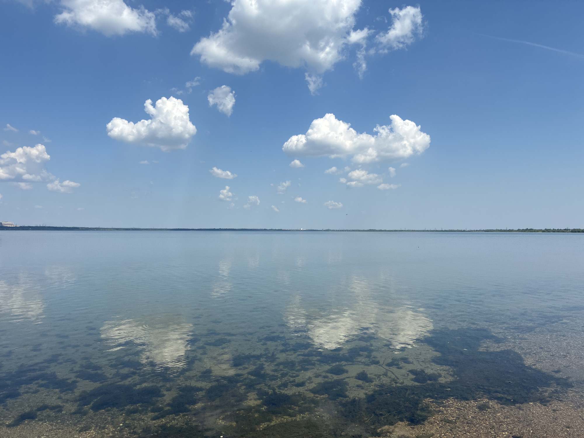 Tranquil waterfront scene captured under scattered clouds Sunday morning