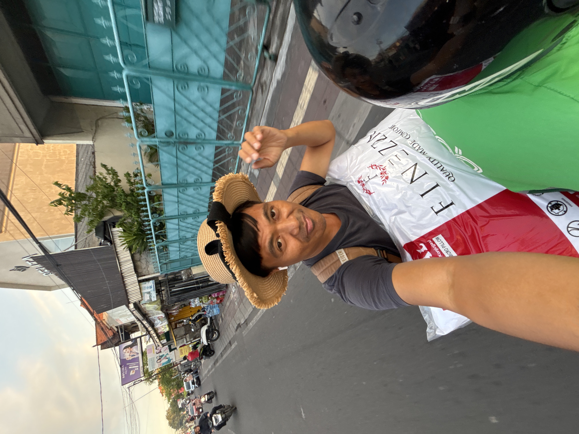 Motorcycle rider hauling a pillow bag through Denpasar streets