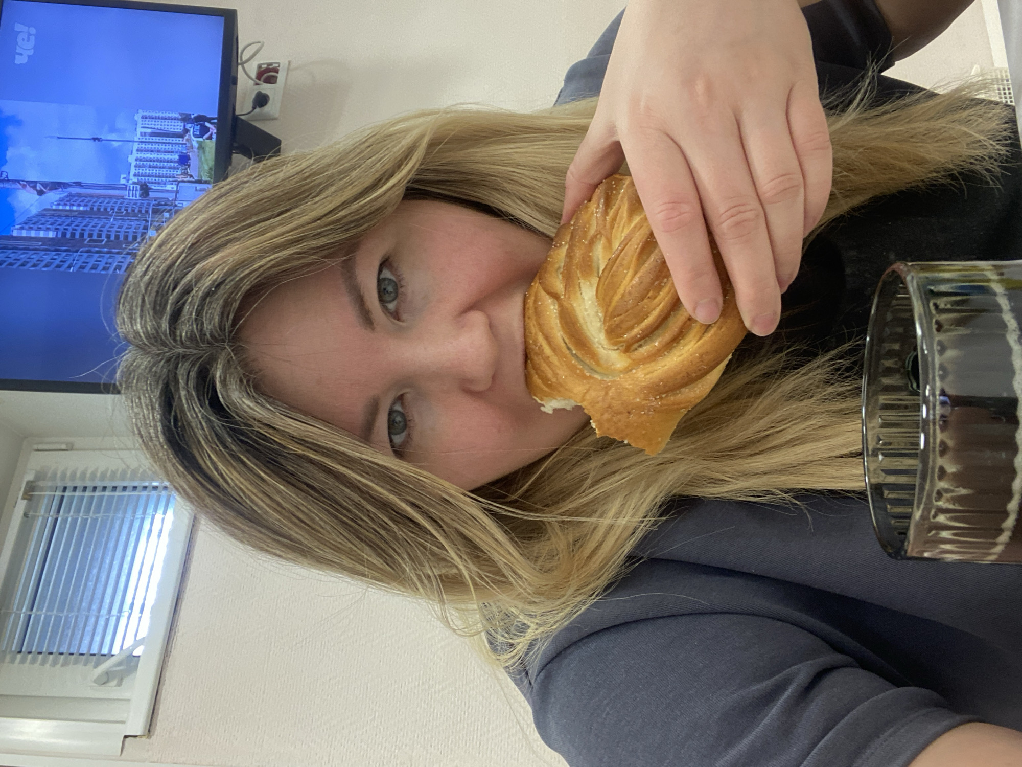 Woman enjoys breakfast pastry and drink in Chaikovsky home