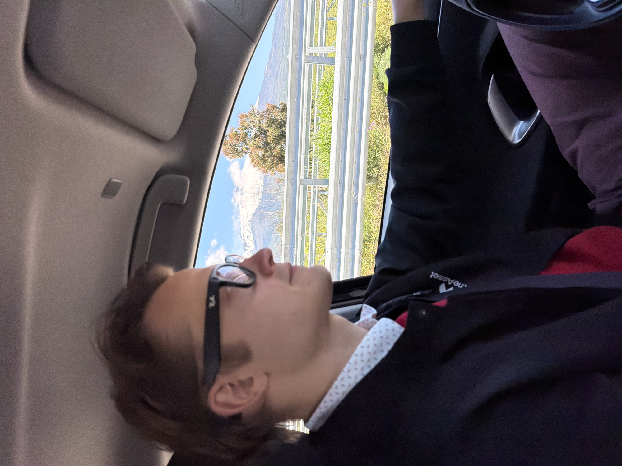 Young man sleeps in car passenger seat in Sicily