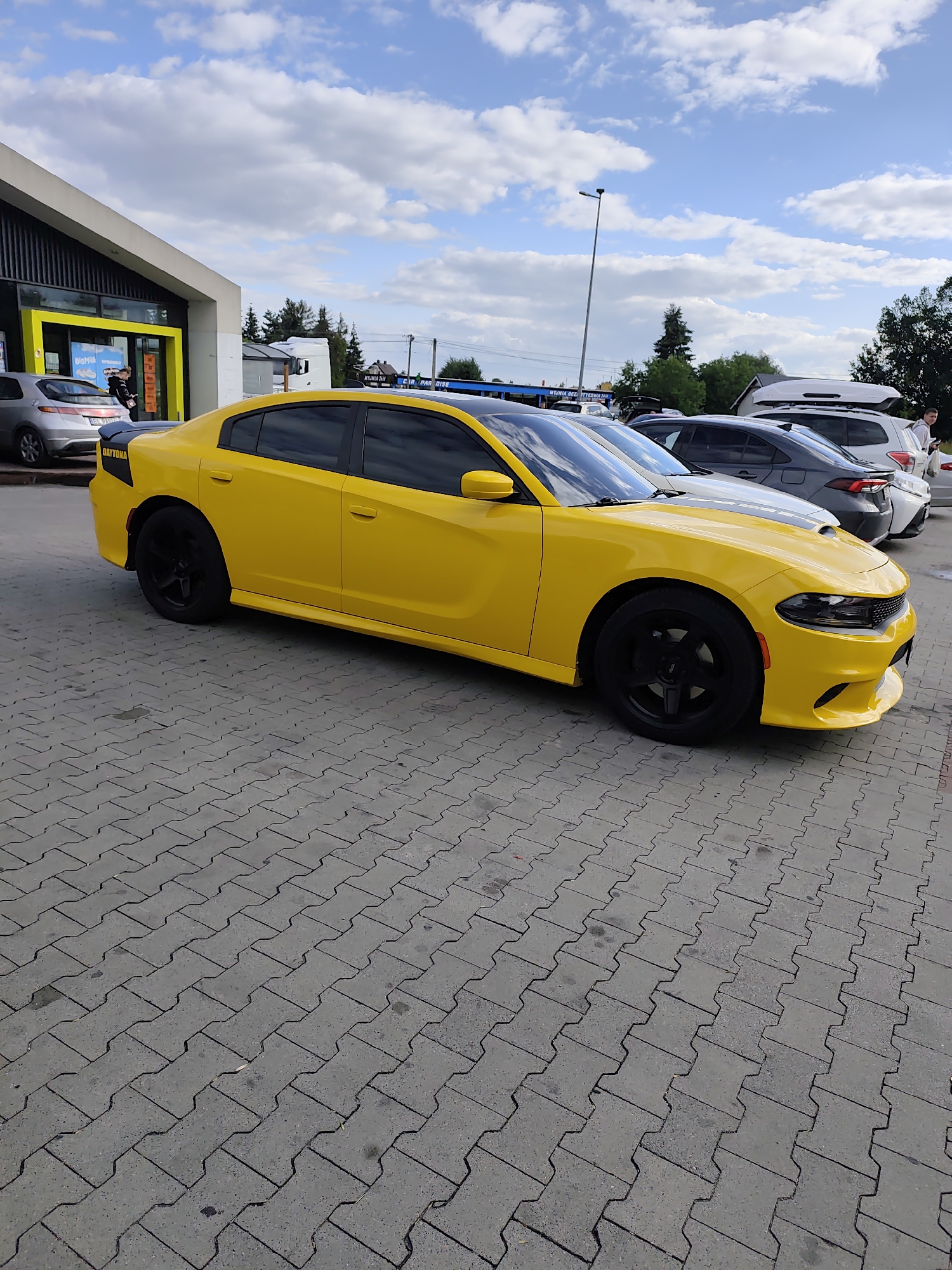 Yellow Dodge Charger Daytona parked on decorative pavers