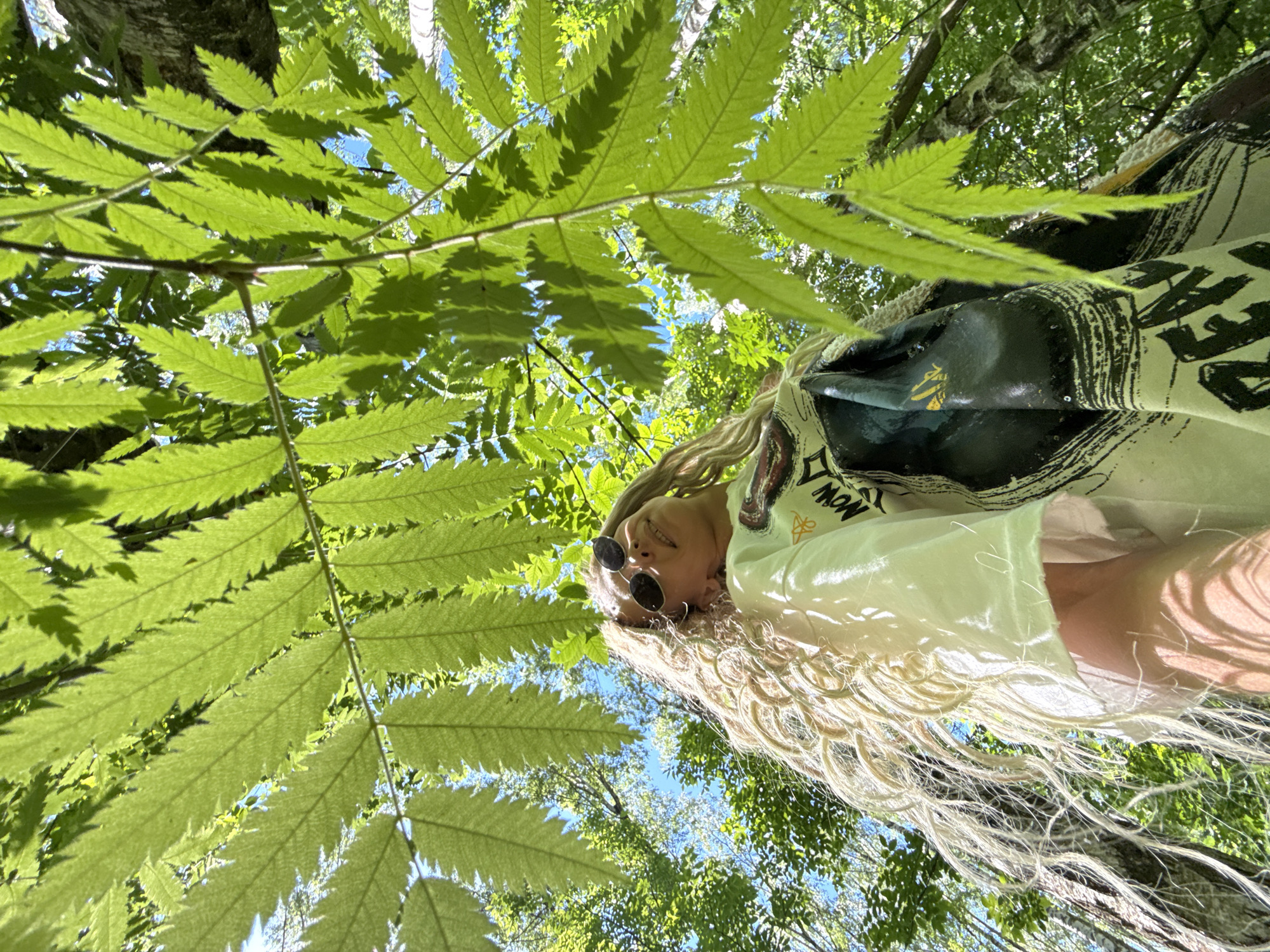 Woman photographs herself in Russian forest, holds wildflowers