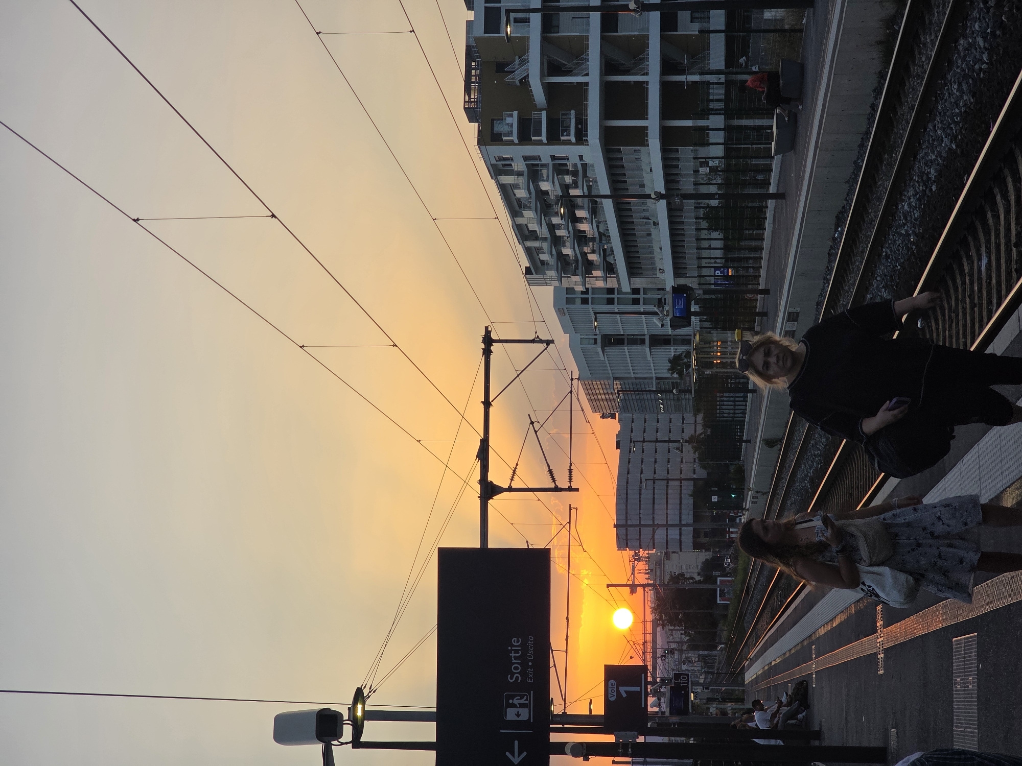 Sunset over Nice's train station, platform life mid-evening.