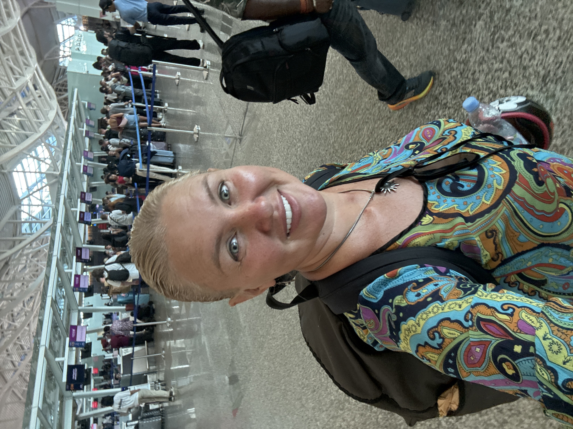 Mother and child navigate Bali airport with luggage cart