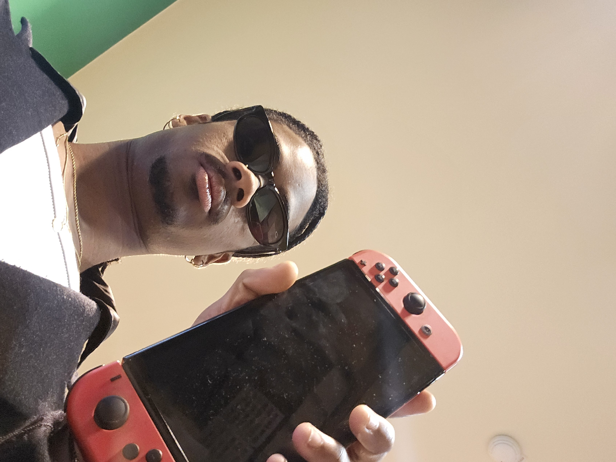 Person with sunglasses holds Nintendo Switch in Paris