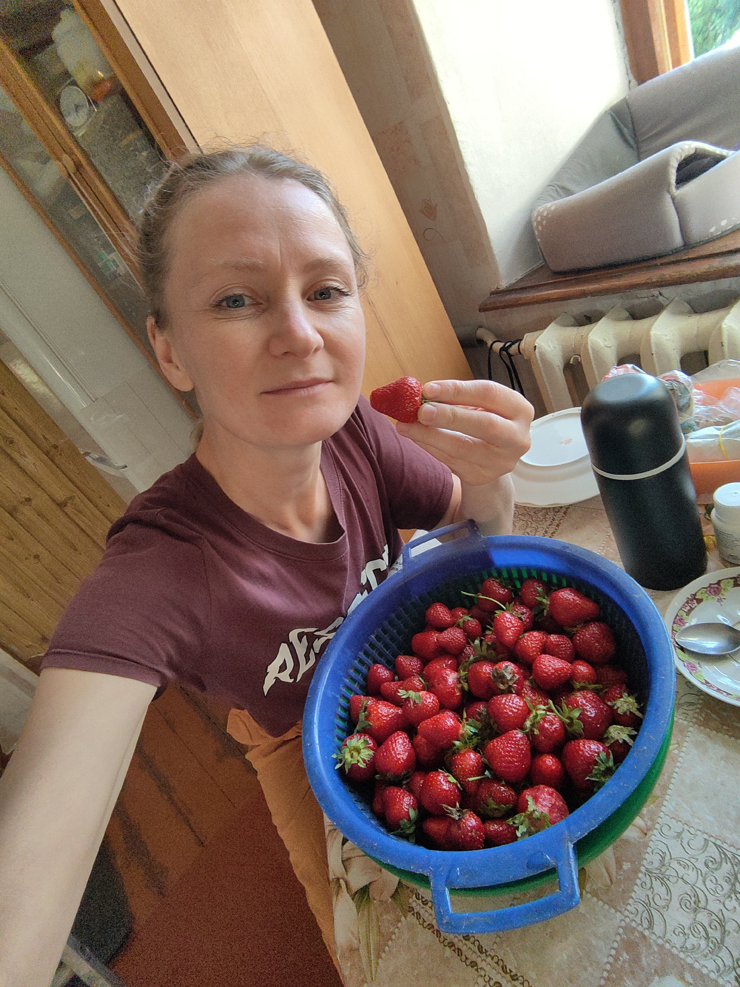 Woman enjoys strawberries, relaxes with kitten in Ukrainian village