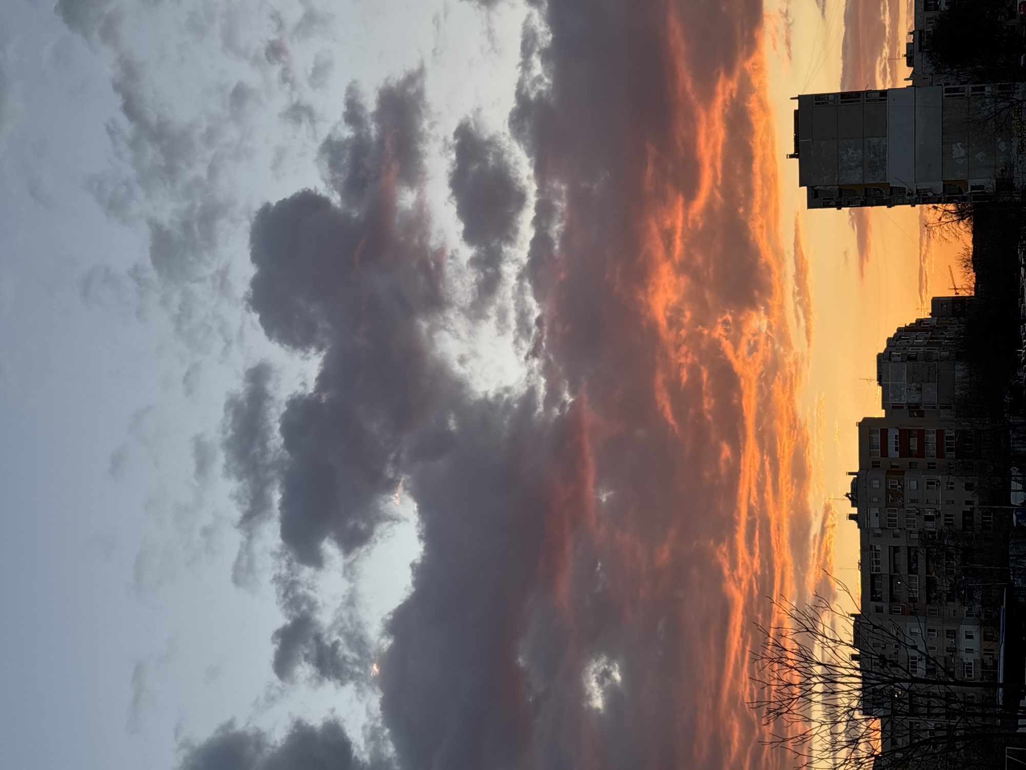 Urban sunset shows dramatic sky contrast between clouds and colors