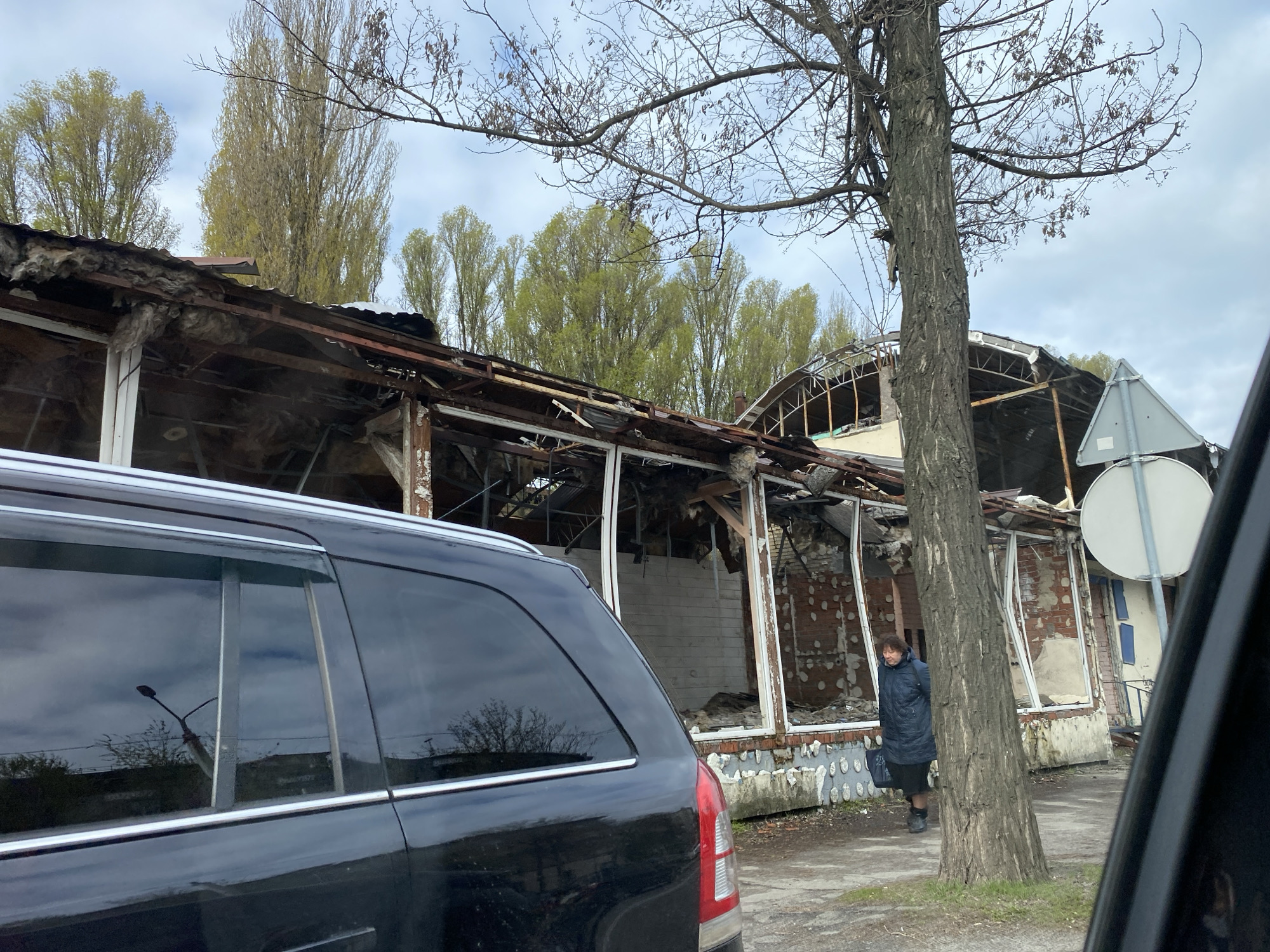 Urban building damage and demolition scenes captured alongside routine traffic
