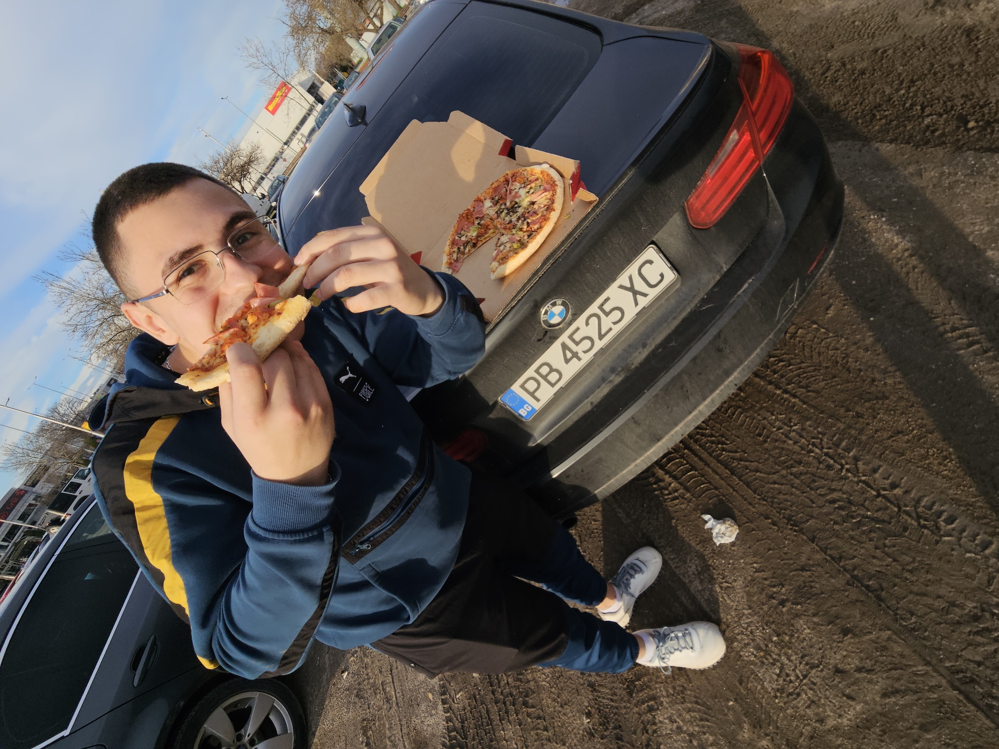 Man eats pizza in Plovdiv parking lot