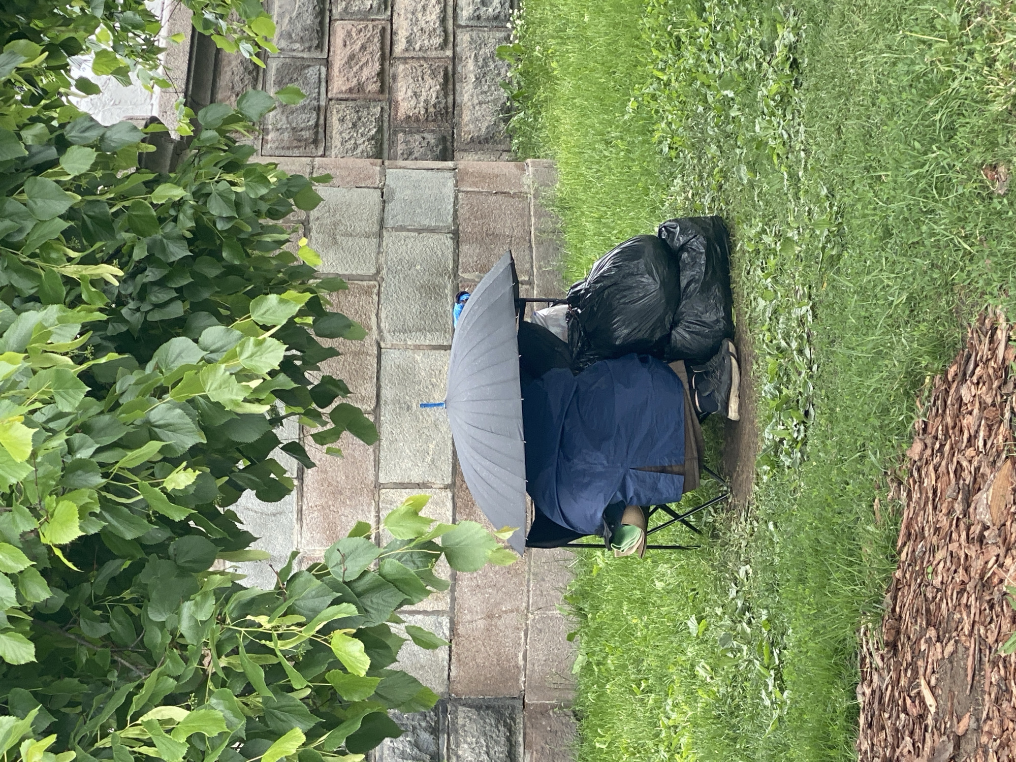 Person sits under umbrella by stone wall in Moscow