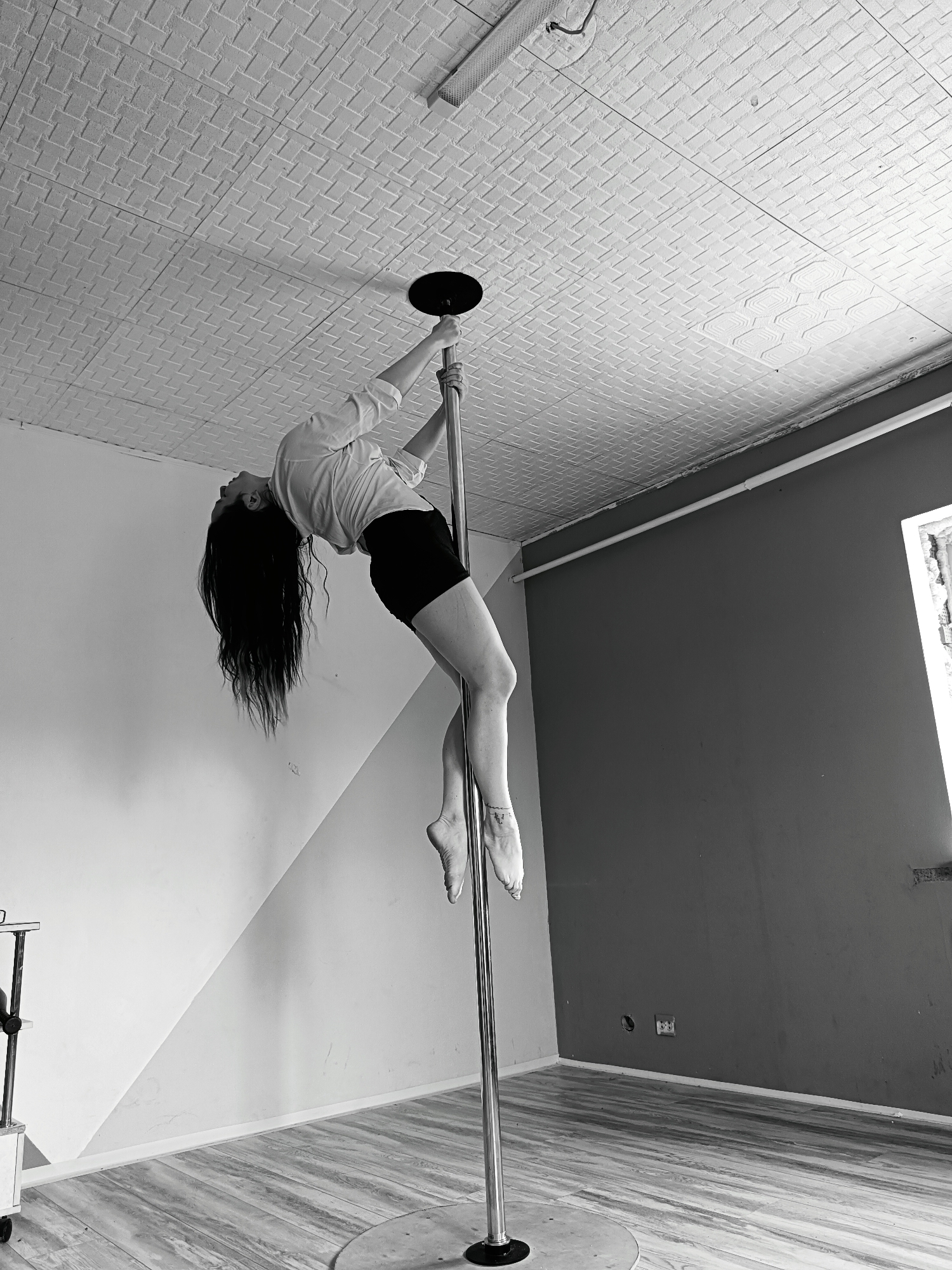 Woman performs pole dance routine in Rusalevka indoor venue