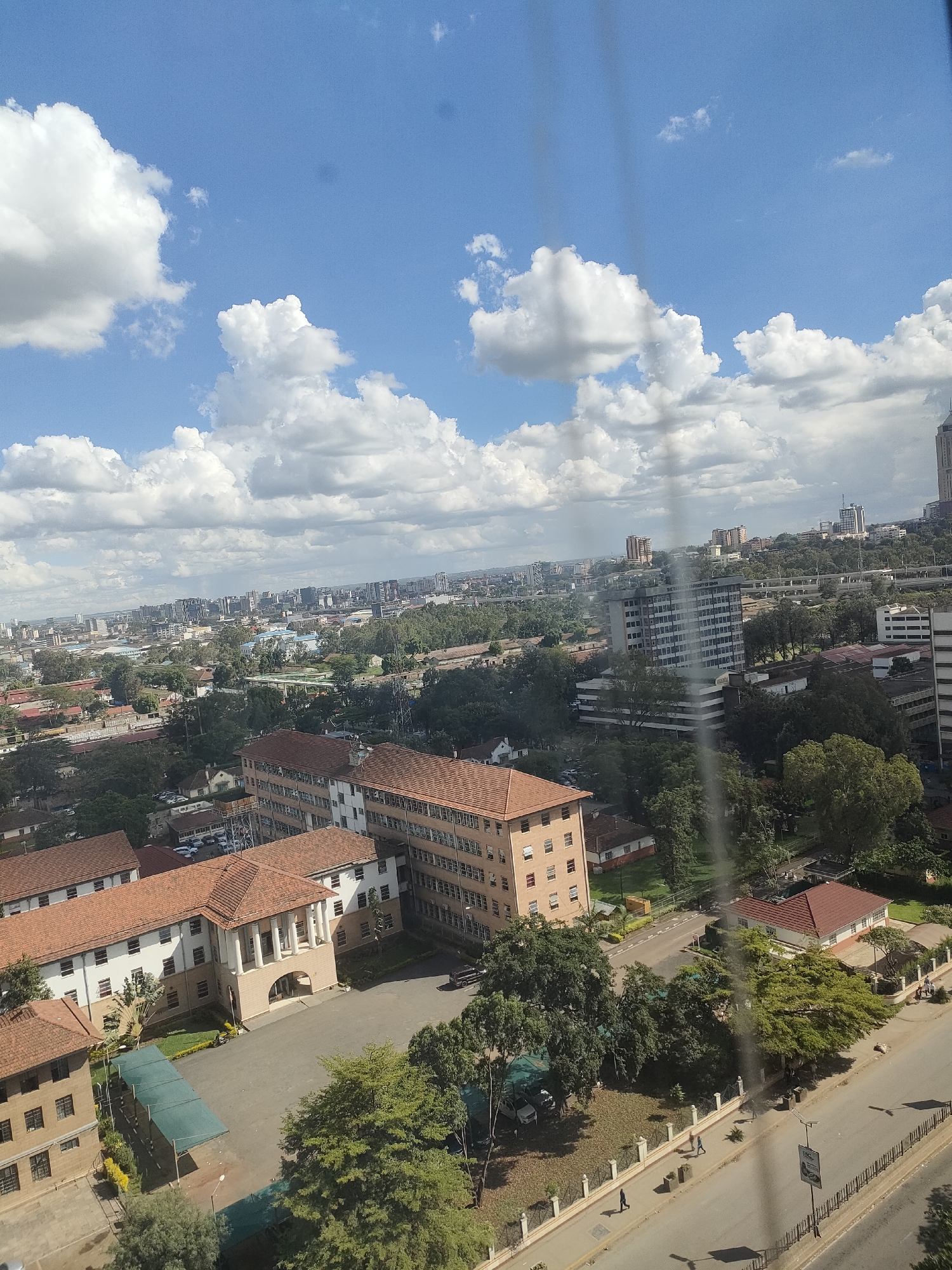 Aerial views document Nairobi cityscape during midday hour