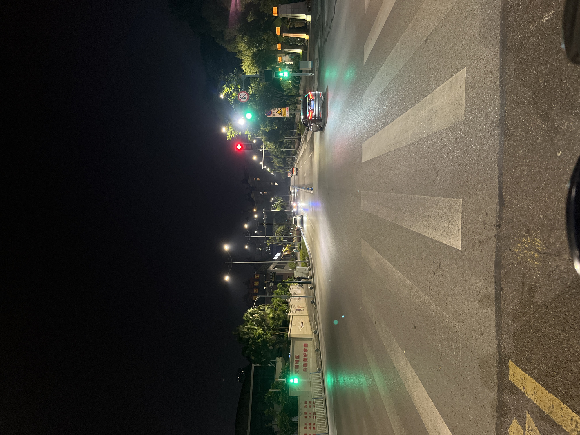 Wet nighttime street intersection documented in Jiulongpo District