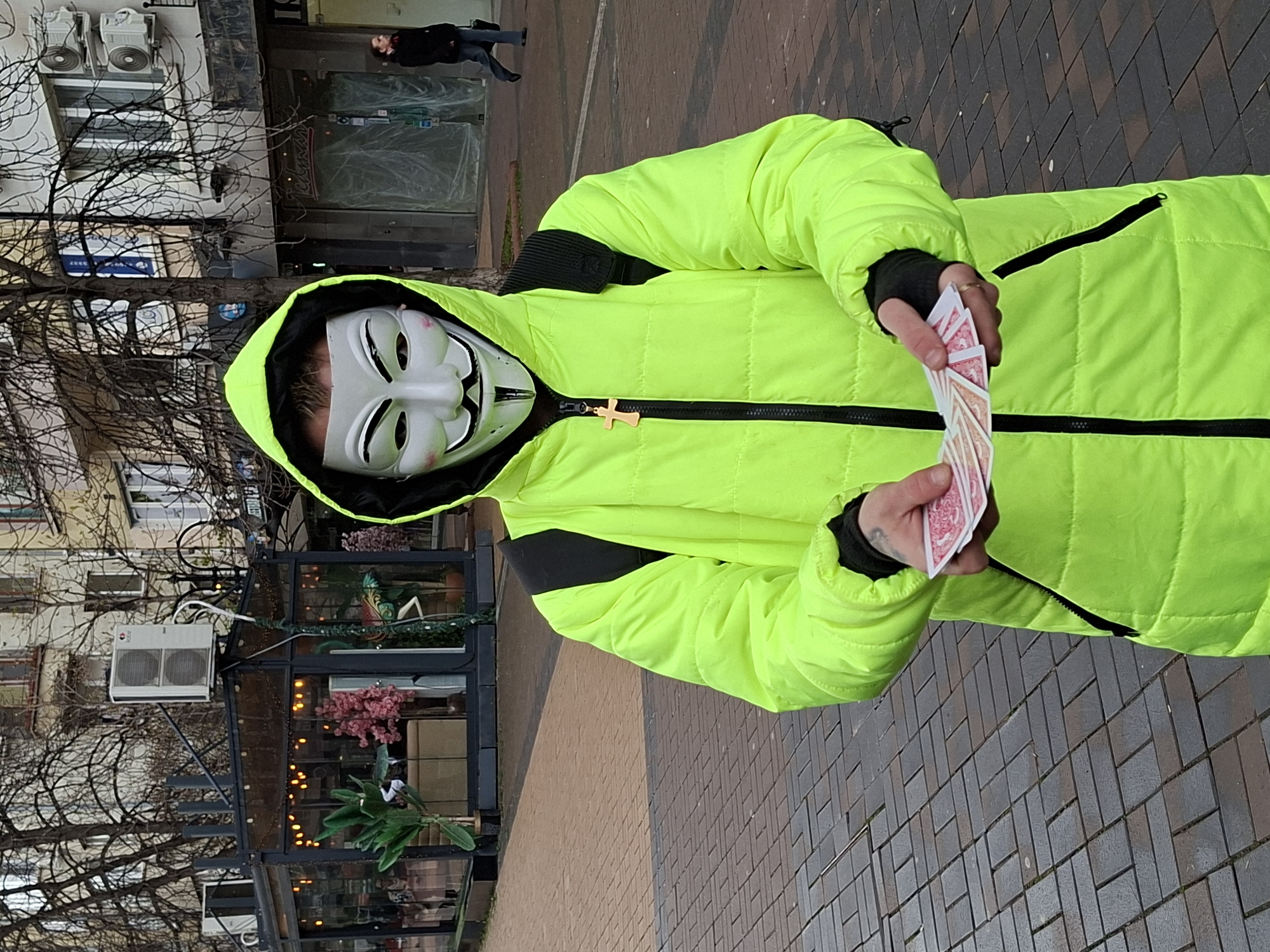 Masked figure with cards, husky dog spotted on Sofia sidewalk