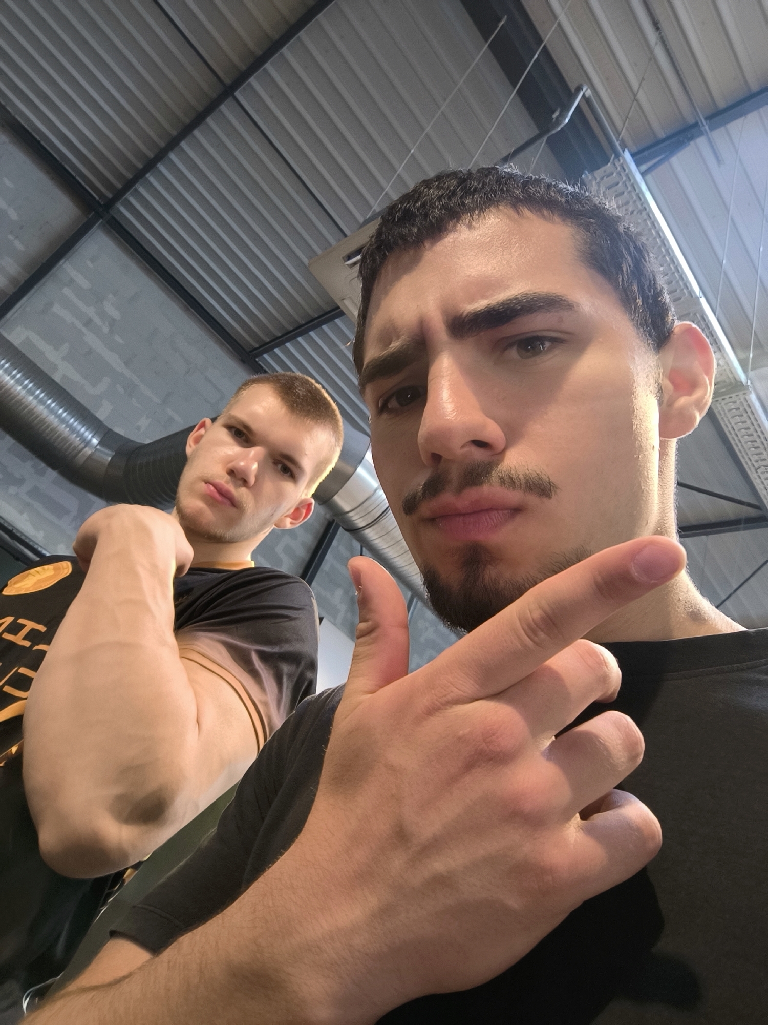 Two men take selfies in industrial space, Hœnheim
