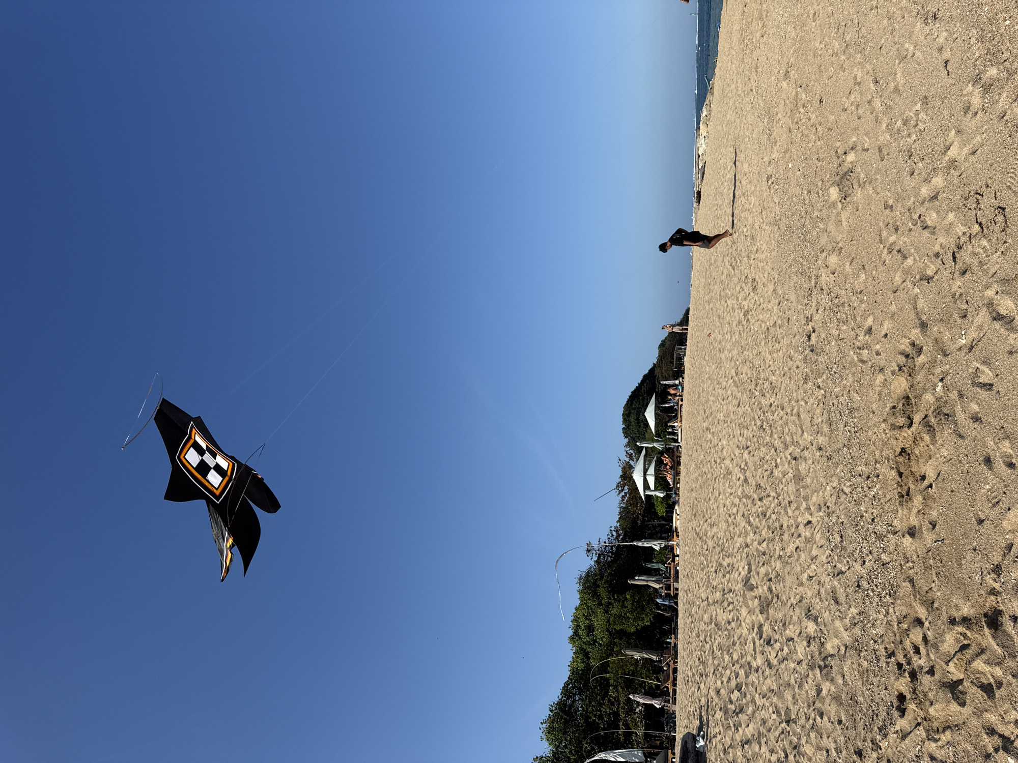 Kites, selfies, and fishing on a Denpasar beach morning