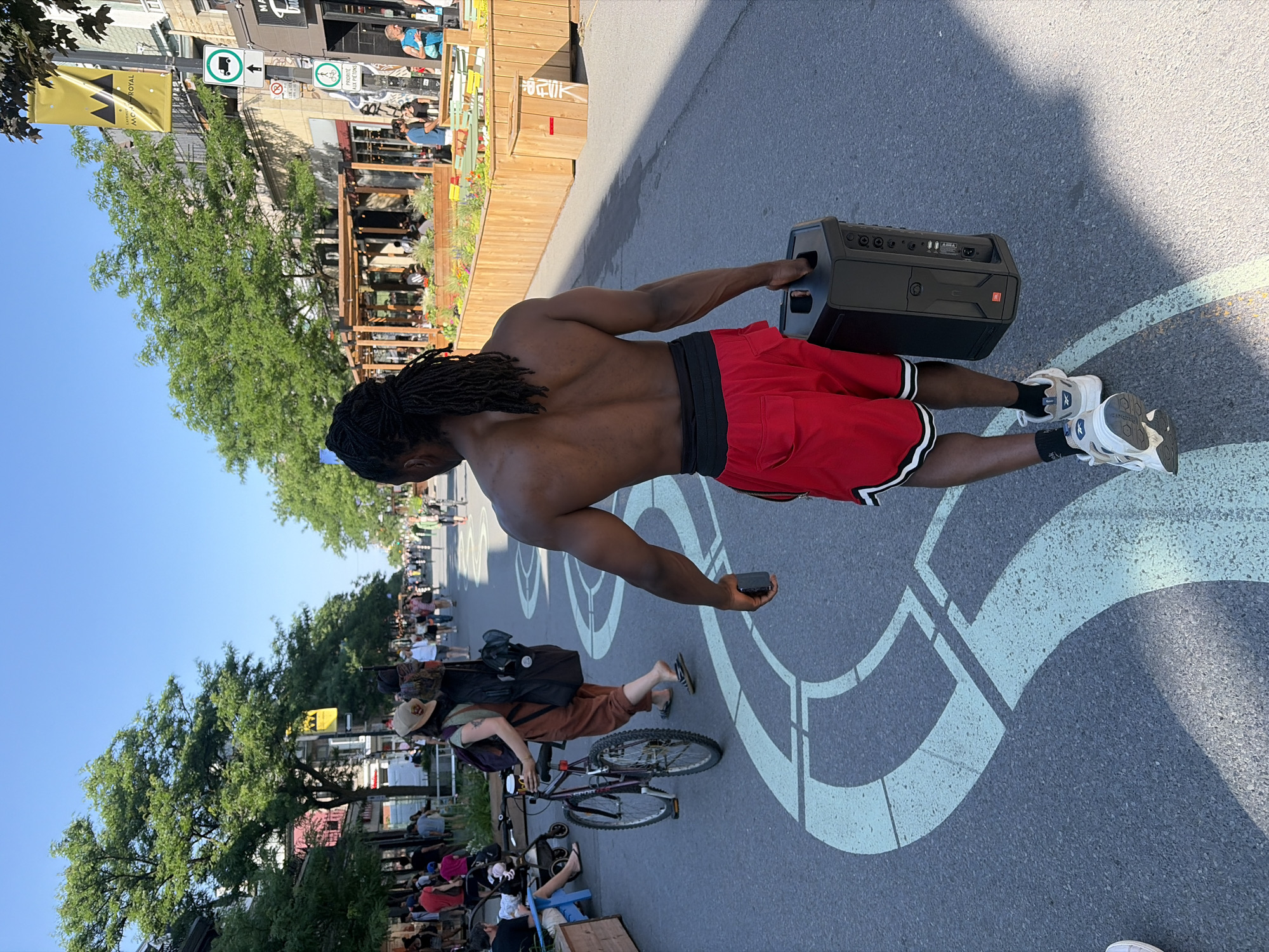 Masked street performer works the poles in downtown Montreal