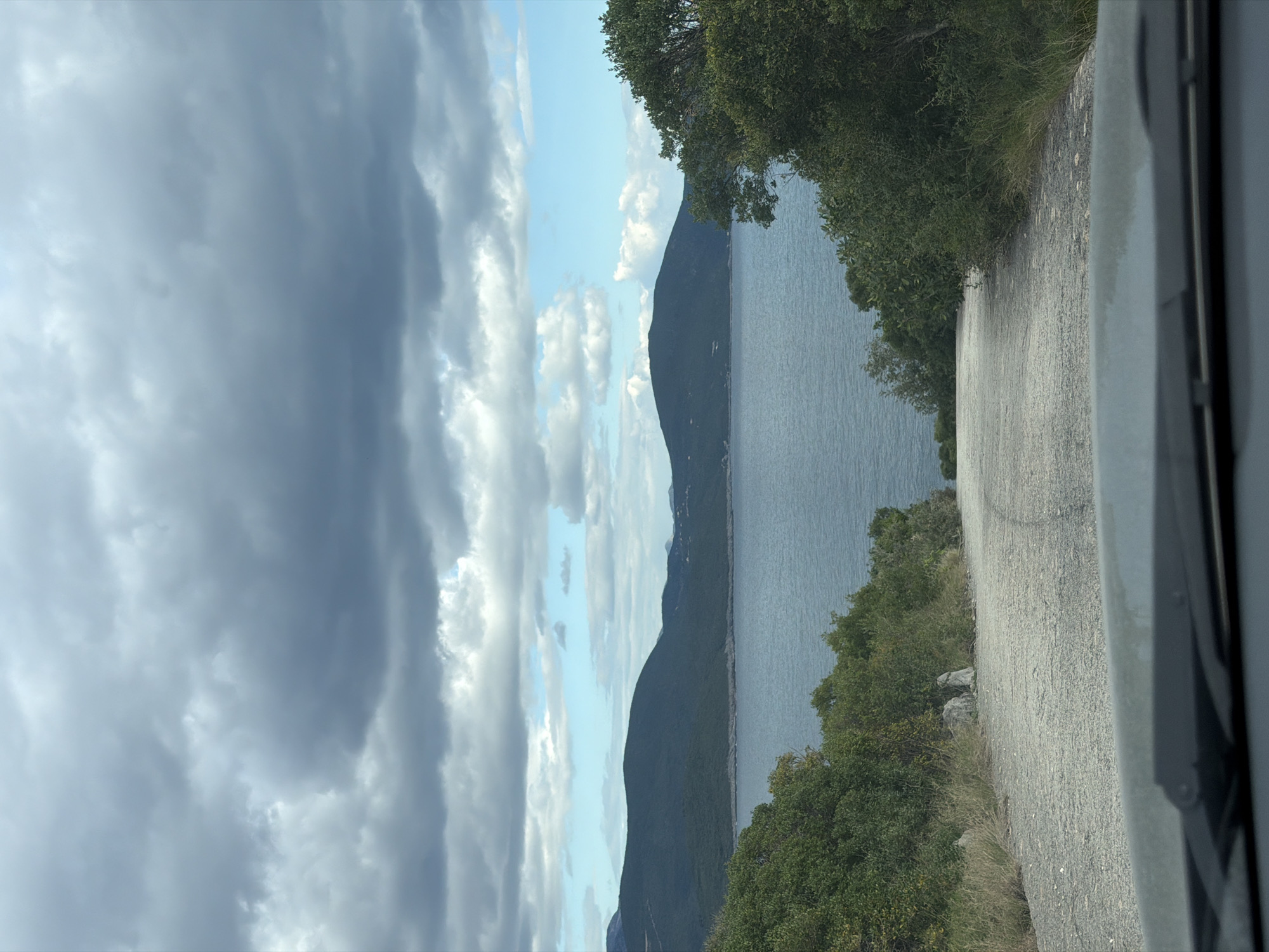Coastal drive documented near Radovići, Montenegro under overcast skies