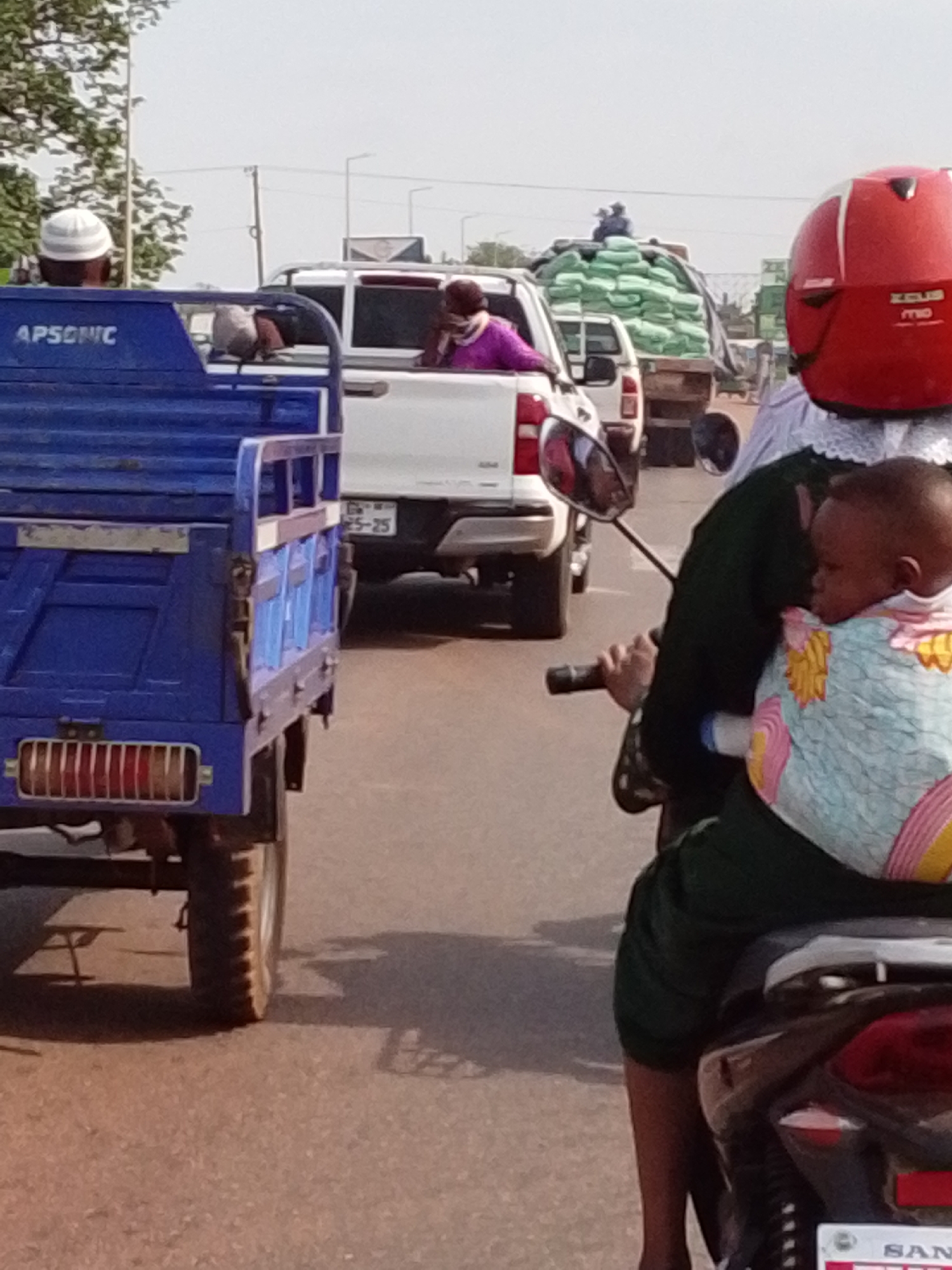 Street scene captured in Dungu, Ghana with vehicles and pedestrian