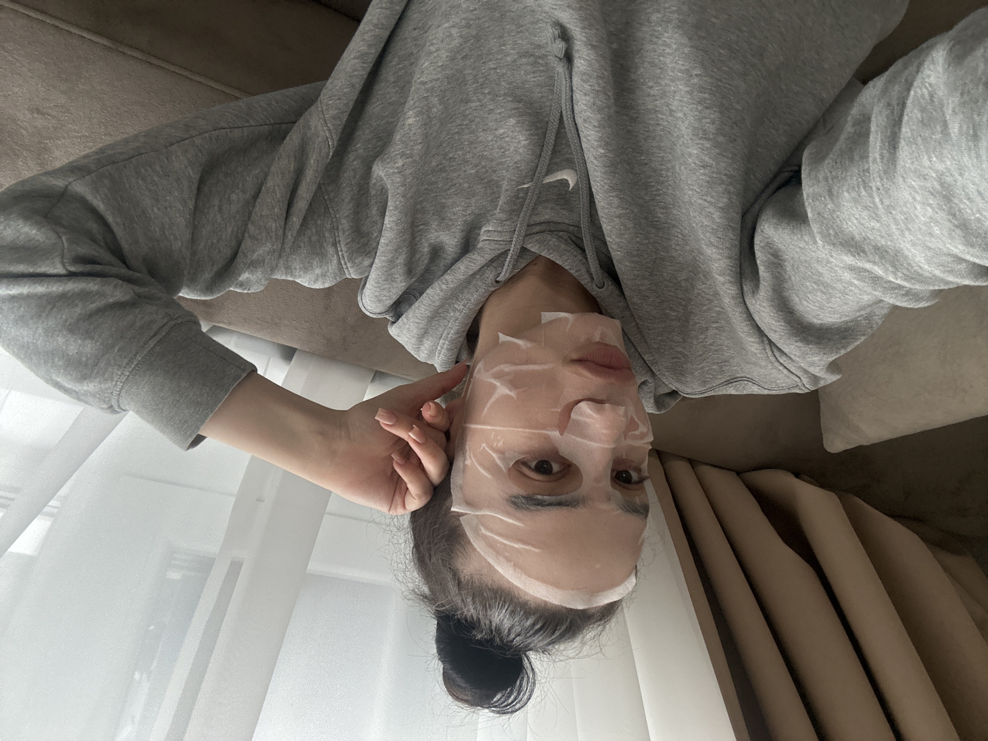 Woman enjoys face mask treatment on couch in Sofia