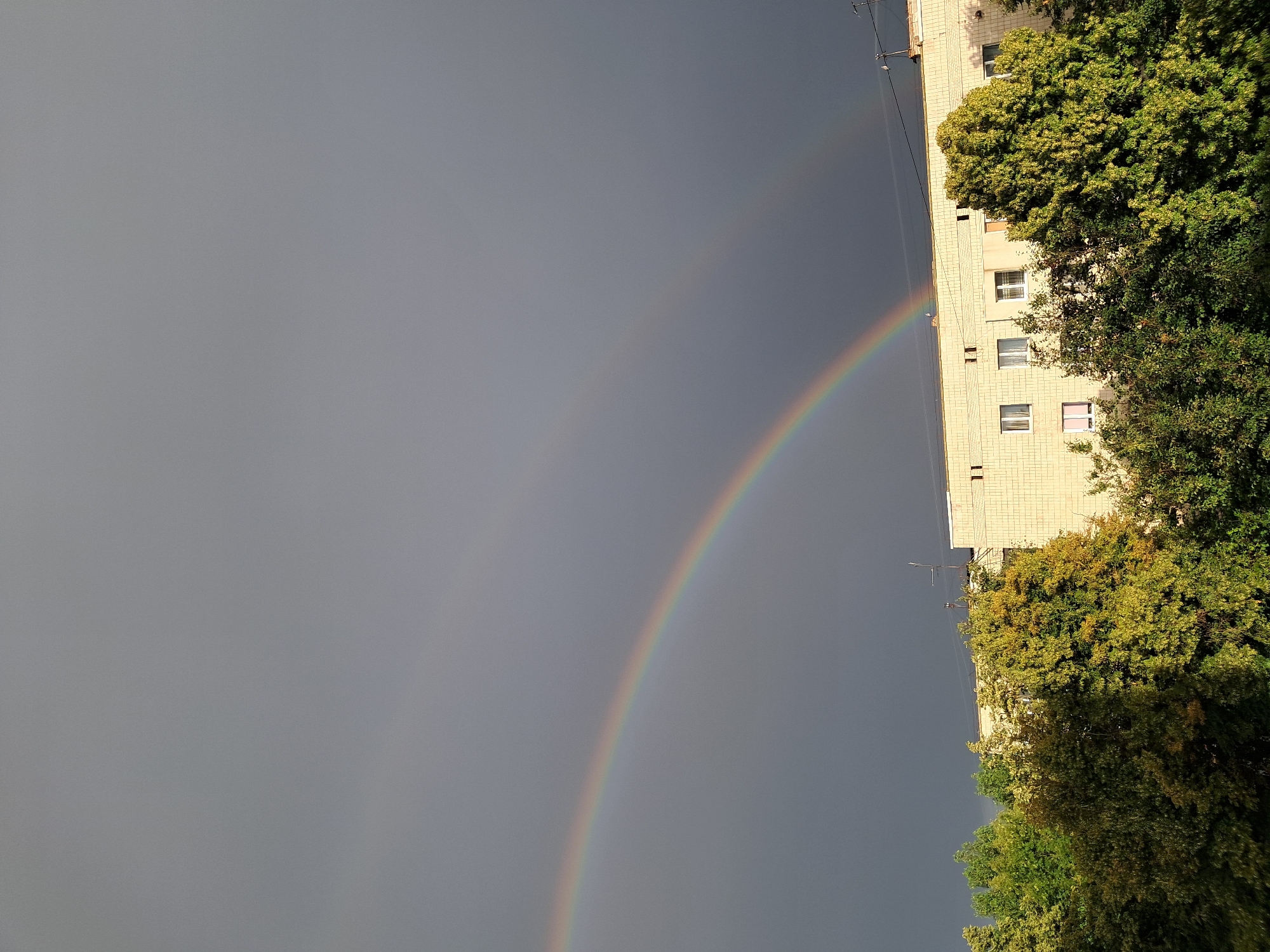 Double rainbow over an urban streetscape after rain