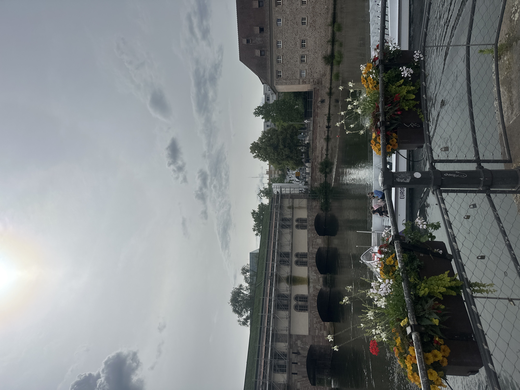 Tourist boats cruise Strasbourg's historic waterways on cloudy afternoon