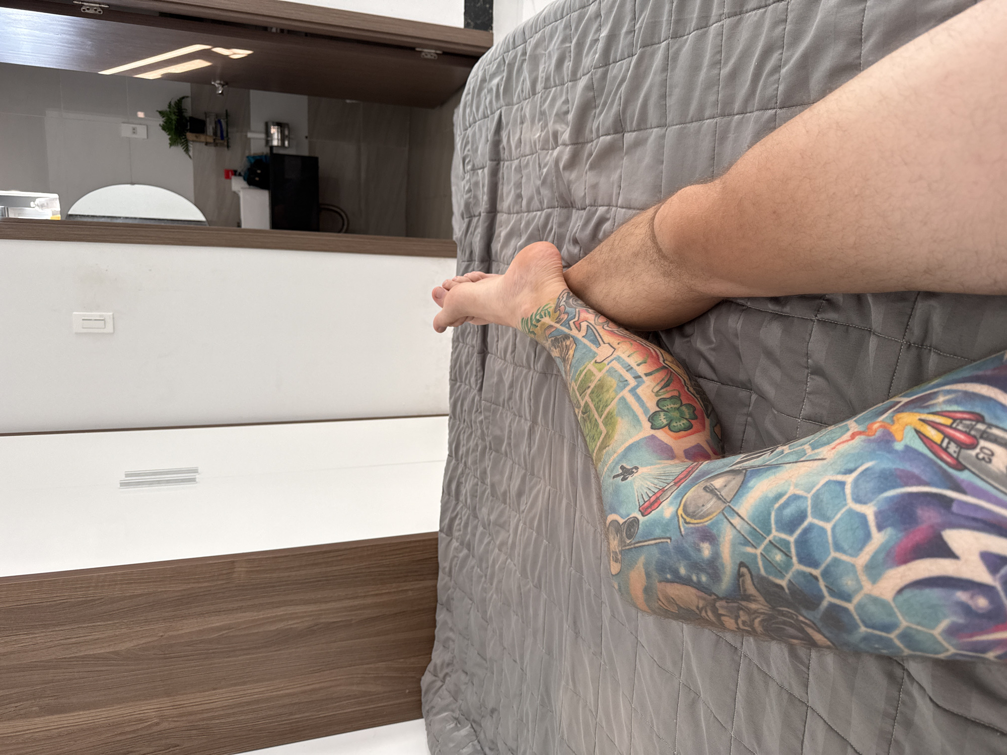 Tattooed leg photographed on bedspread in Vietnam