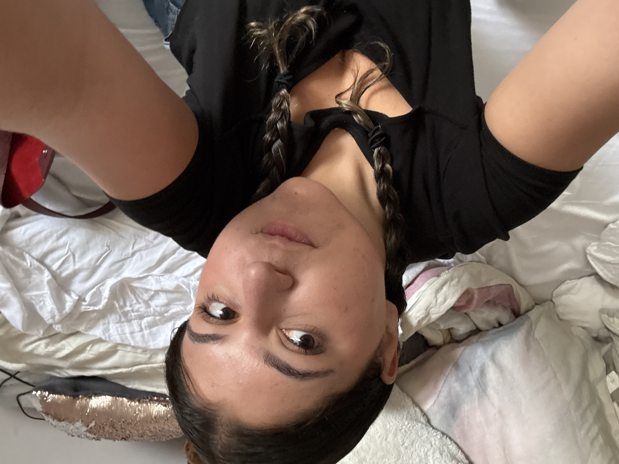 Woman takes overhead selfie on bed in Mexico City