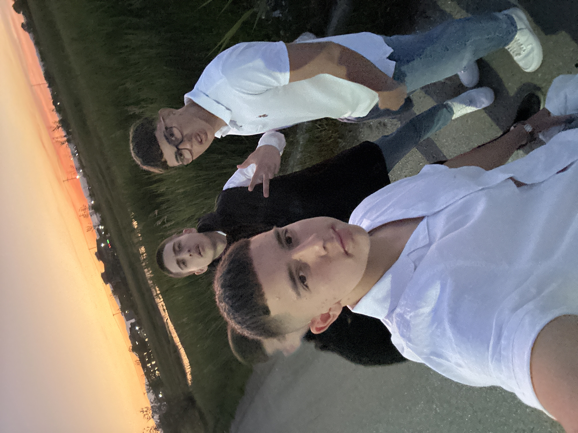 Three men pose for photo during sunset in Greece
