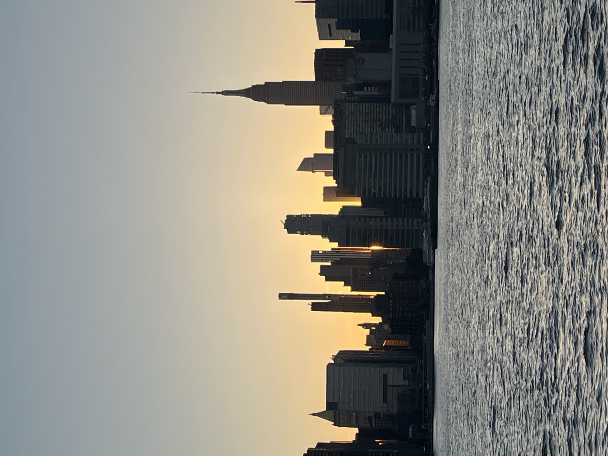 Manhattan skyline glows at sunset from East River waterfront
