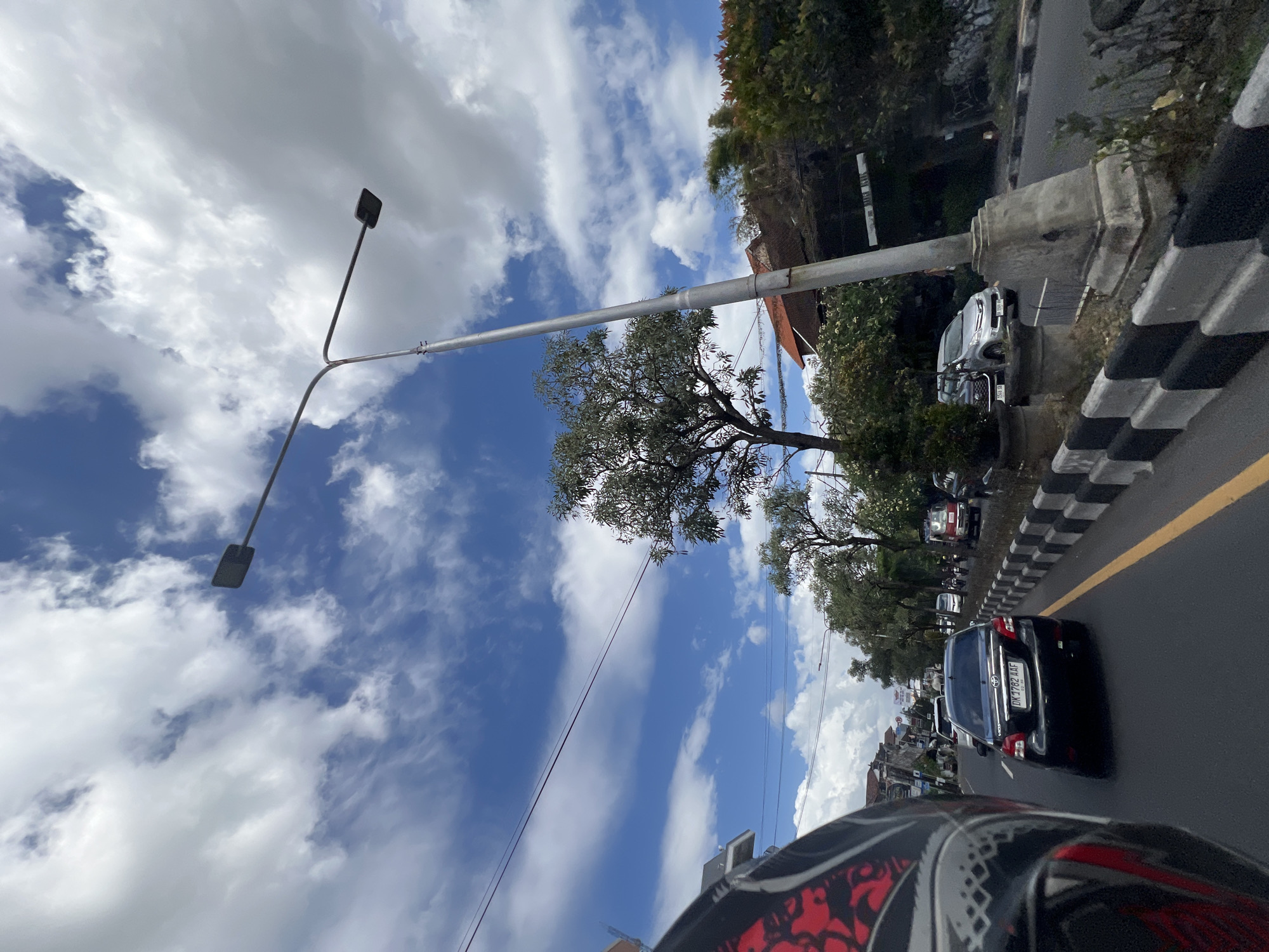 Motorcycle street scenes rolling through cloudy Denpasar