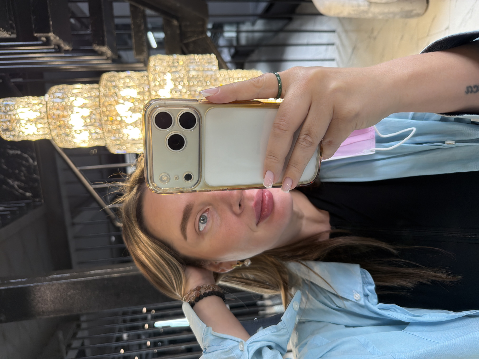Woman takes chandelier selfie with gold iPhone in Moscow