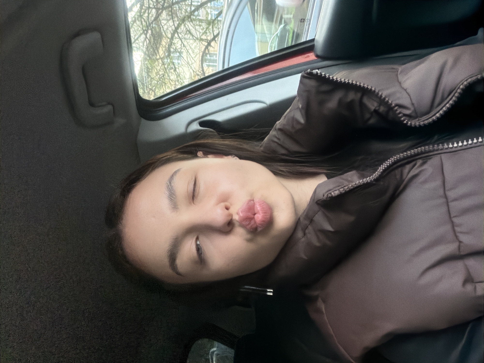 Woman takes playful car selfies in Pernik, Bulgaria
