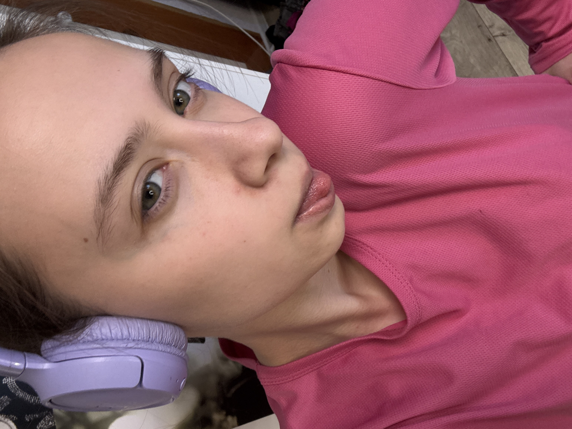Woman in pink top photographed with purple headphones in Russia