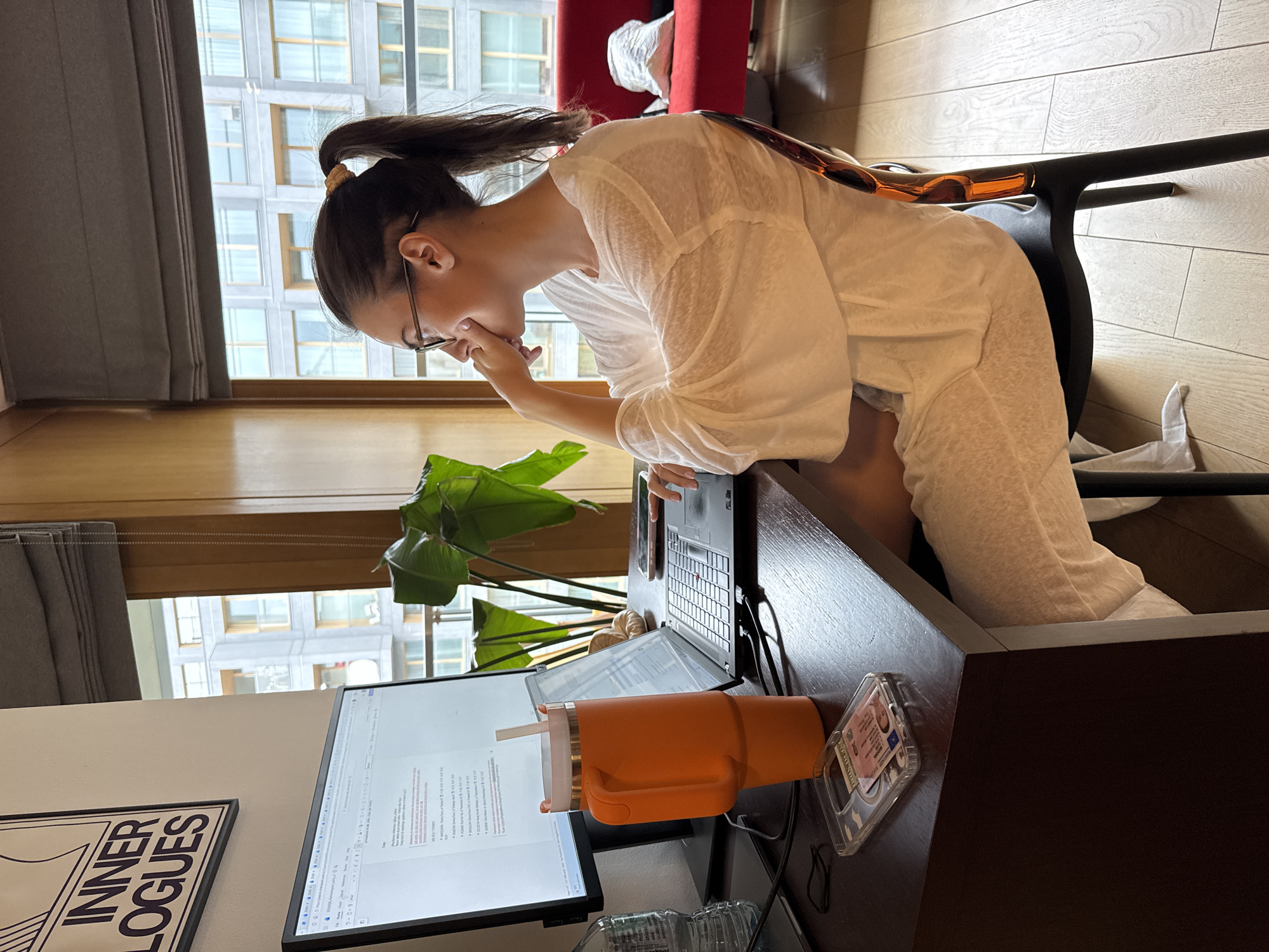 Woman observed in thoughtful pose at desk workspace
