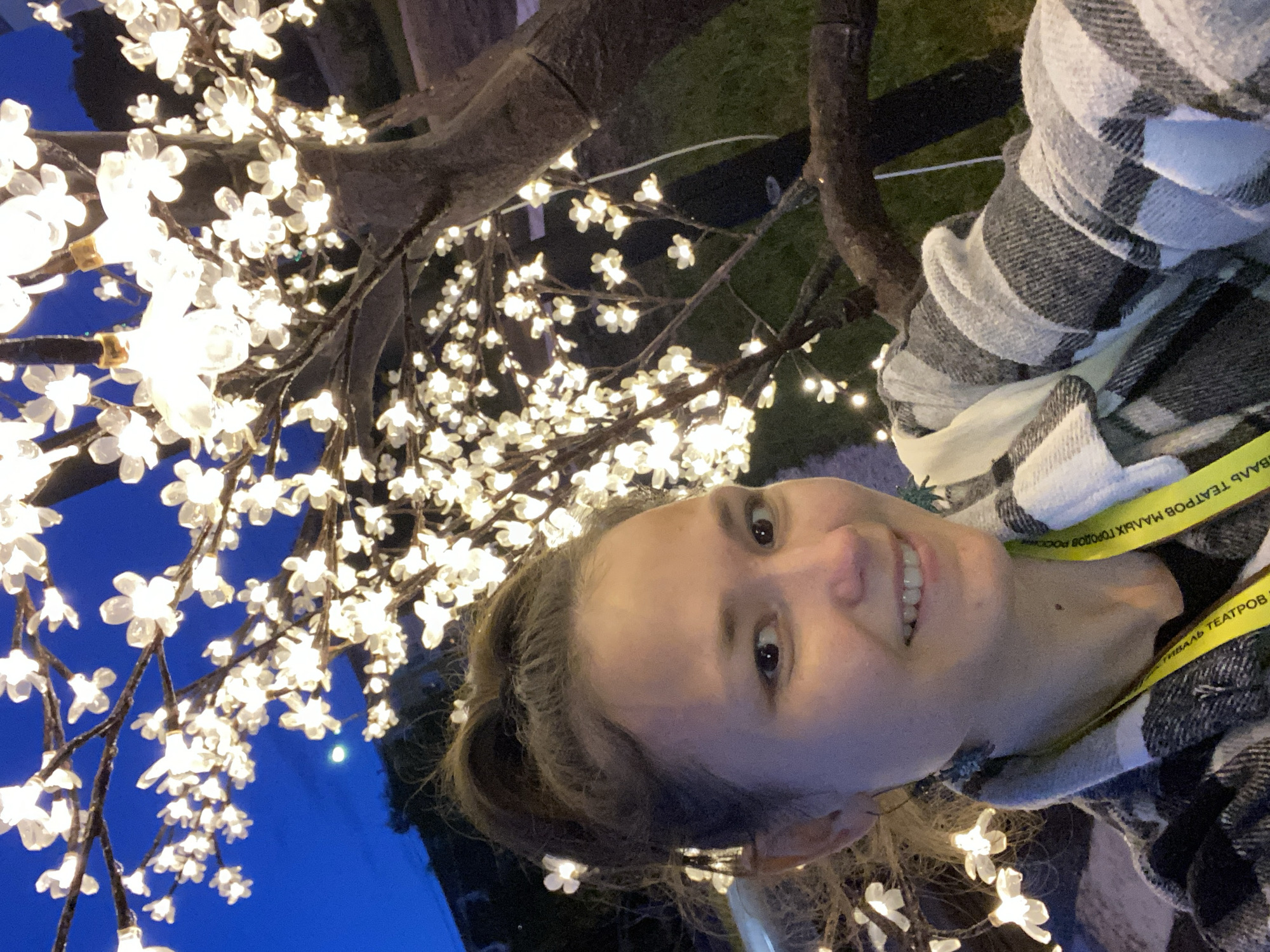 Woman poses by illuminated tree in Peresvet, Russia
