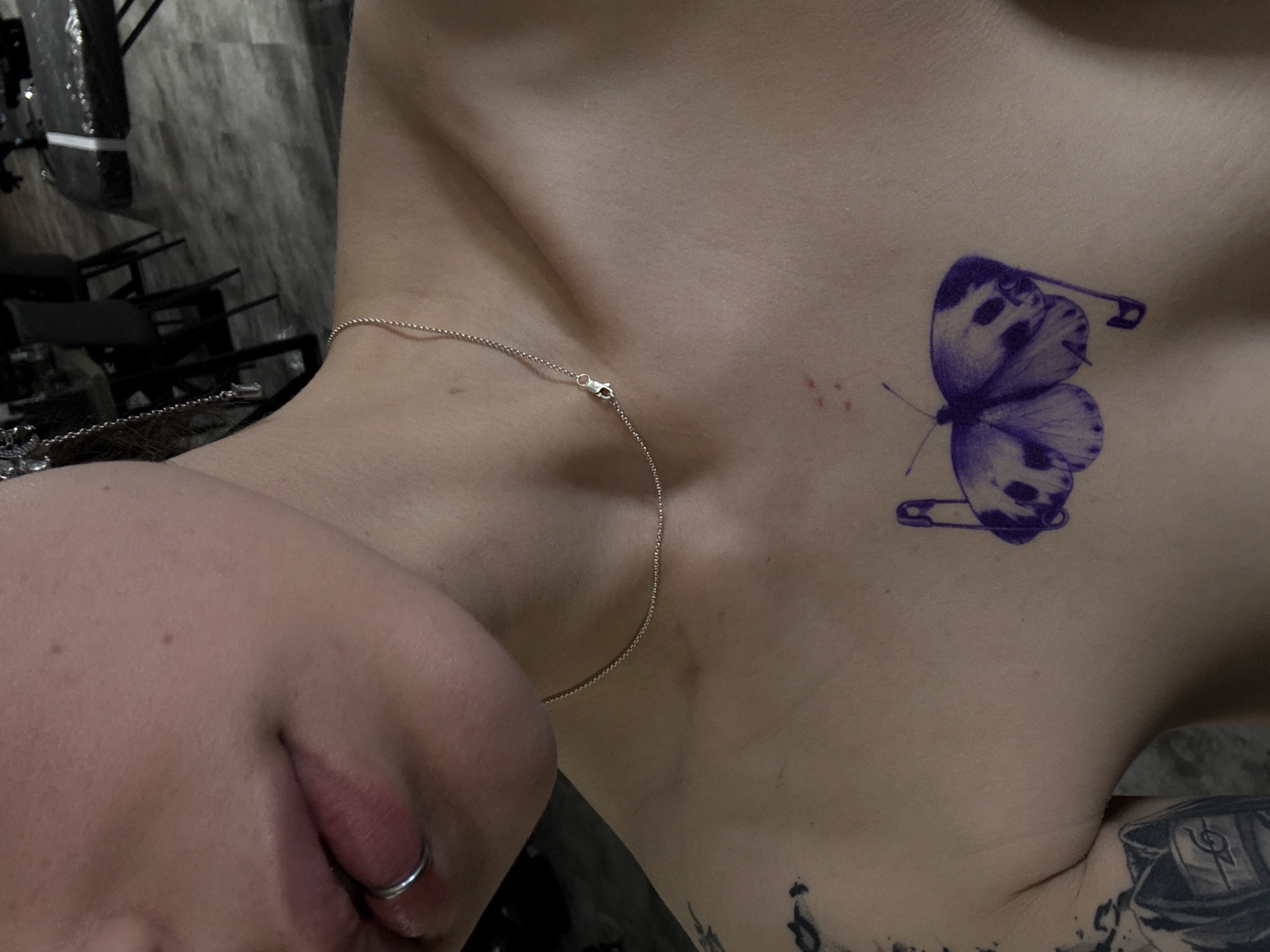 Person displays butterfly tattoo with safety pins in Moscow