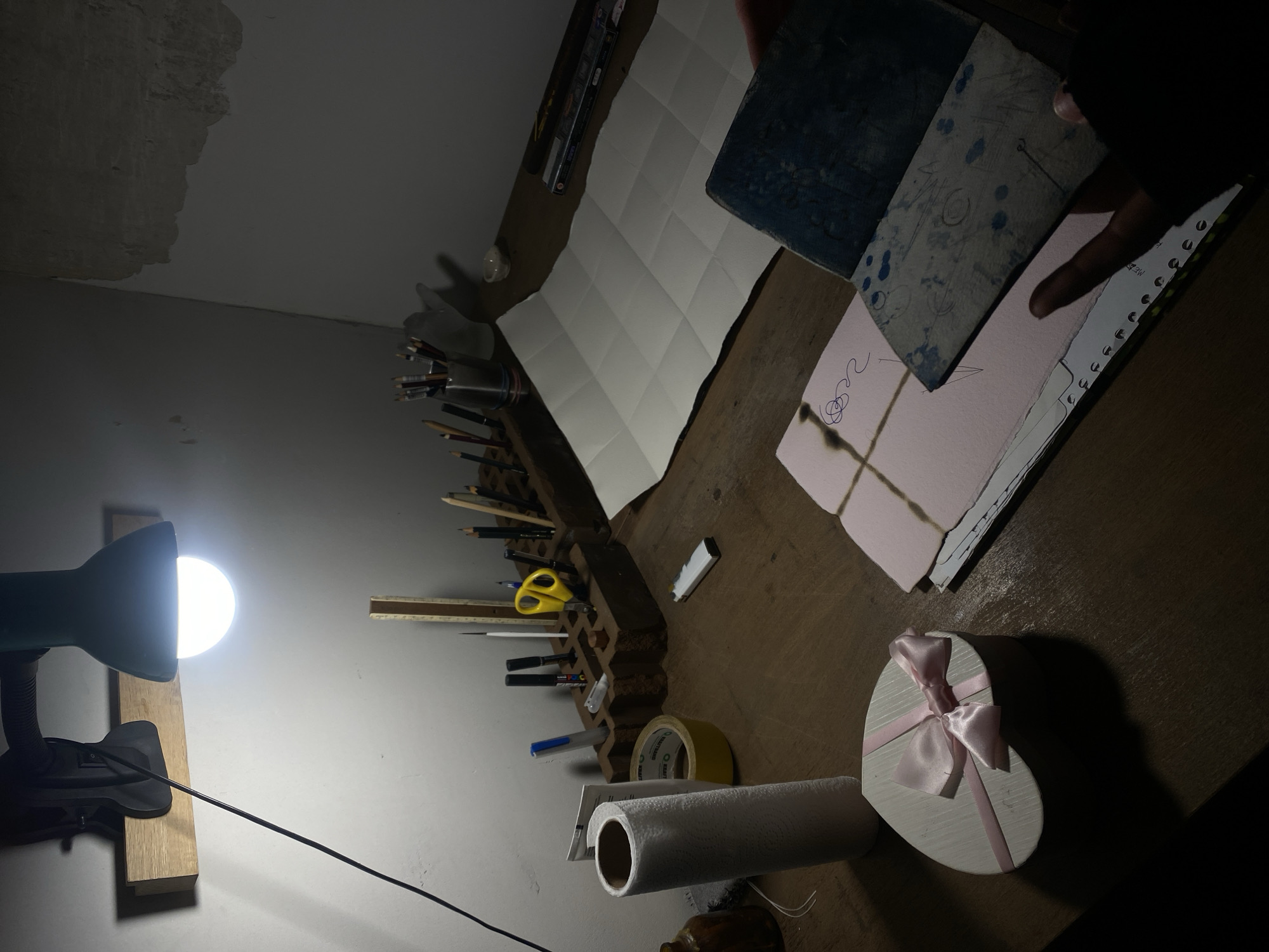 Art workspace documented under desk lamp in Moscow